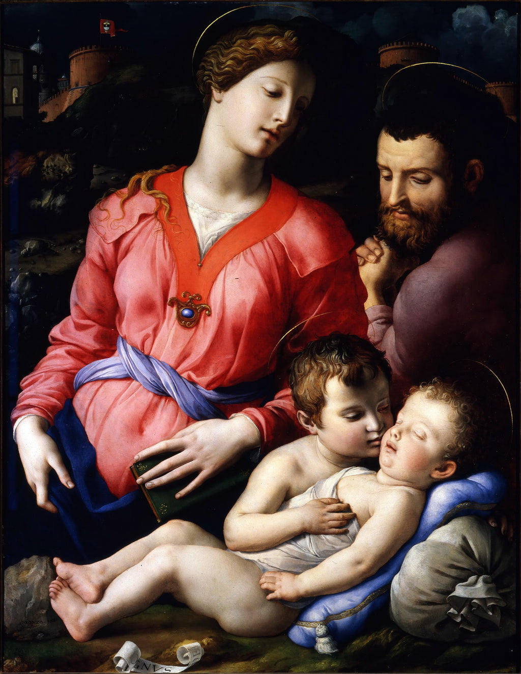 Quadro decorativo da Sagrada Família com São João Batista por Bronzino, com Maria, José e os dois meninos, Jesus e São João, em tons vibrantes de rosa, azul e marrom, sobre um fundo escuro com uma paisagem fortificada ao fundo. Detalhes de auréolas douradas e expressão serena nos rostos.