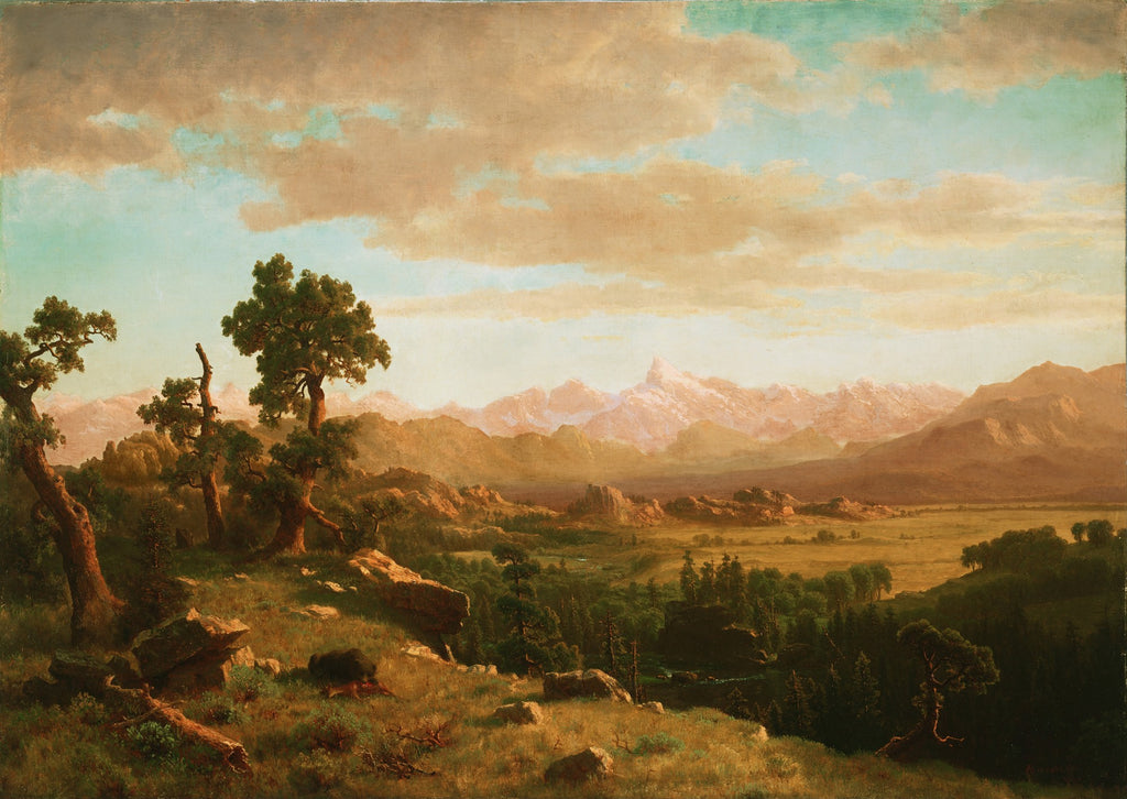 Uma paisagem montanhosa grandiosa em tons terrosos e céu azul claro com nuvens, com árvores em primeiro plano e picos nevados ao fundo, pintada por Albert Bierstadt. A imagem é uma impressão fine art em papel Kodak com moldura e vidro.