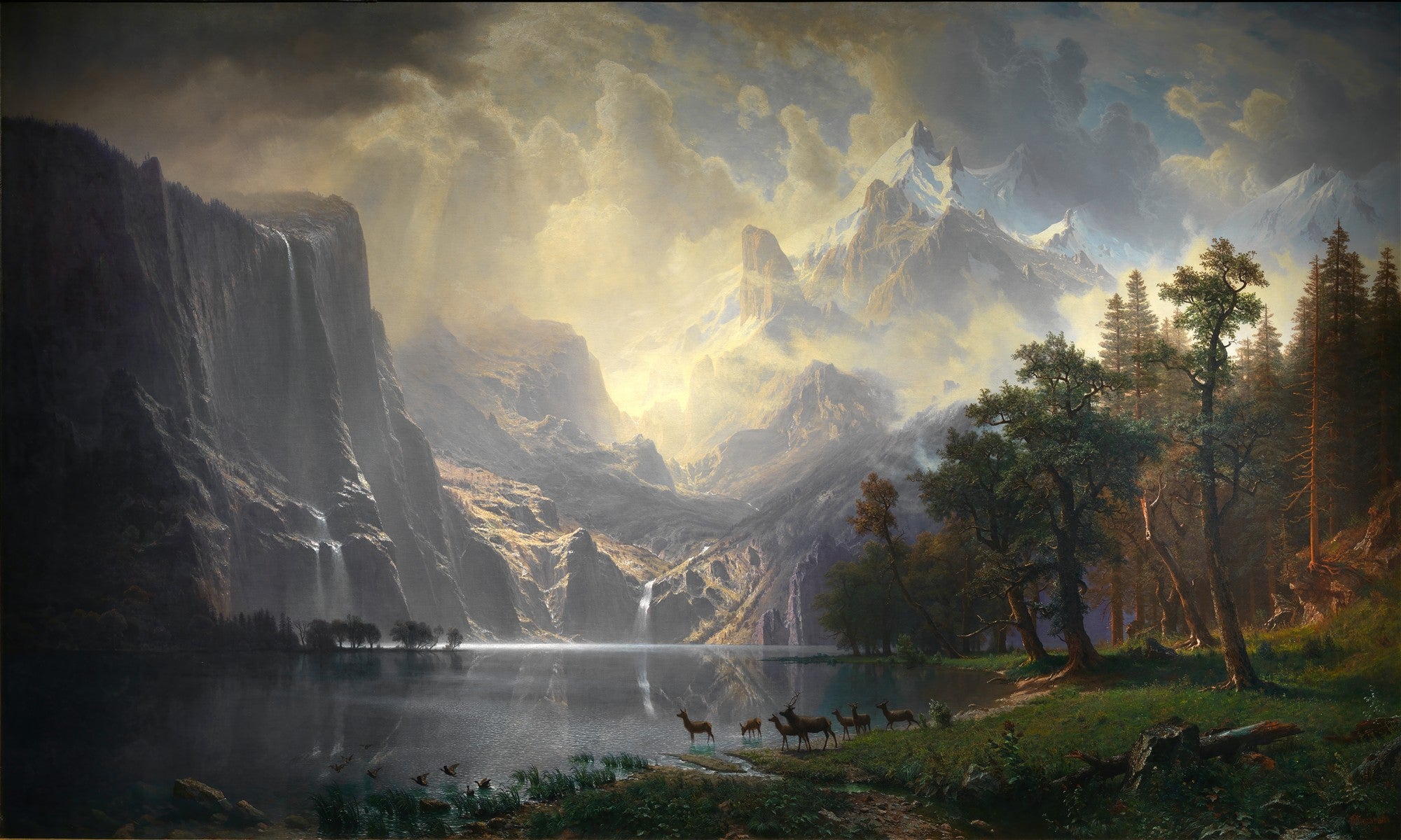 Quadro decorativo paisagem montanhosa com lago, cachoeiras e cervos, sob luz dourada e céu nublado, estilo Albert Bierstadt.