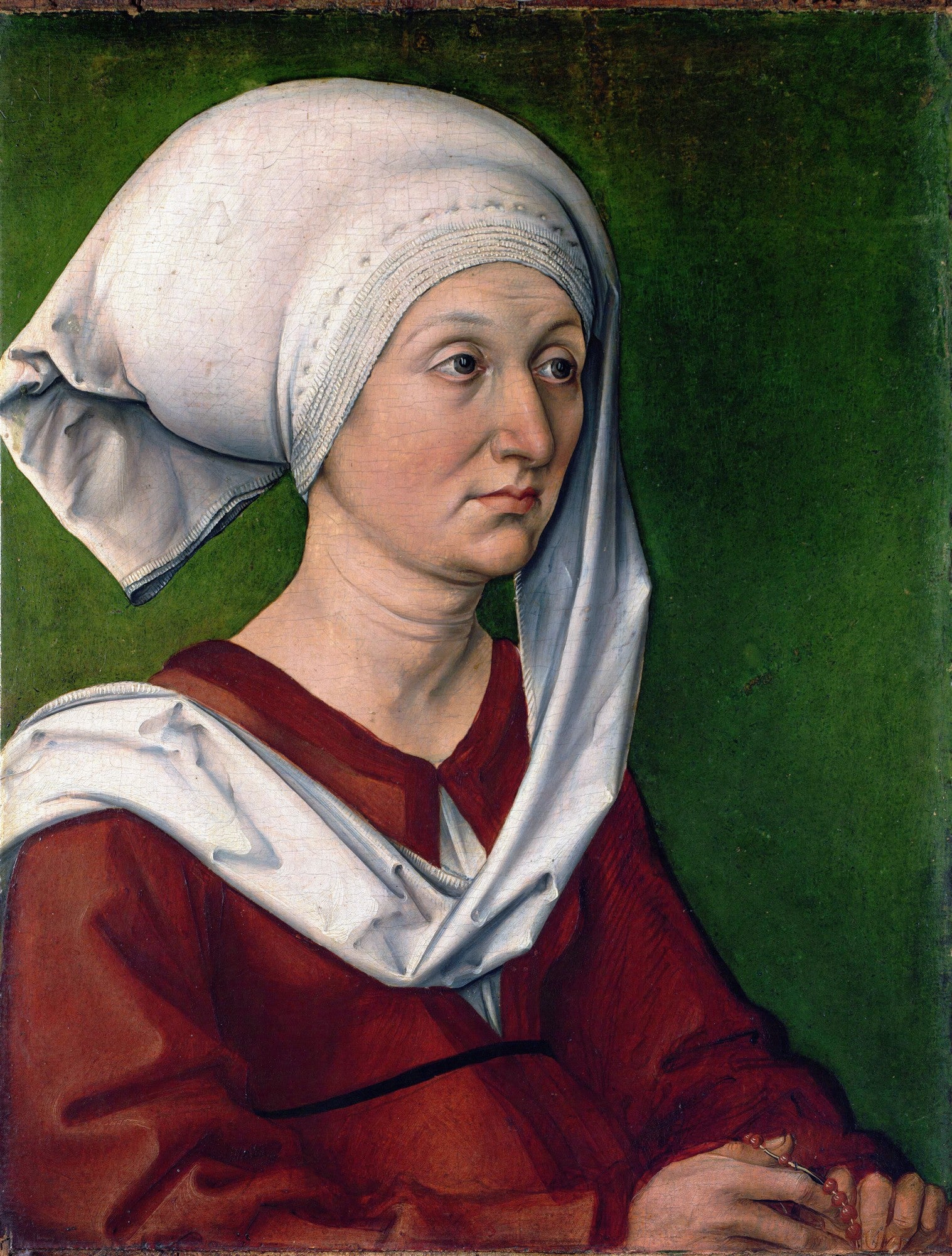 Retrato de uma mulher de meia-idade com touca branca e vestes vermelhas, fundo verde escuro. Pintura atribuída a Albrecht Dürer.
