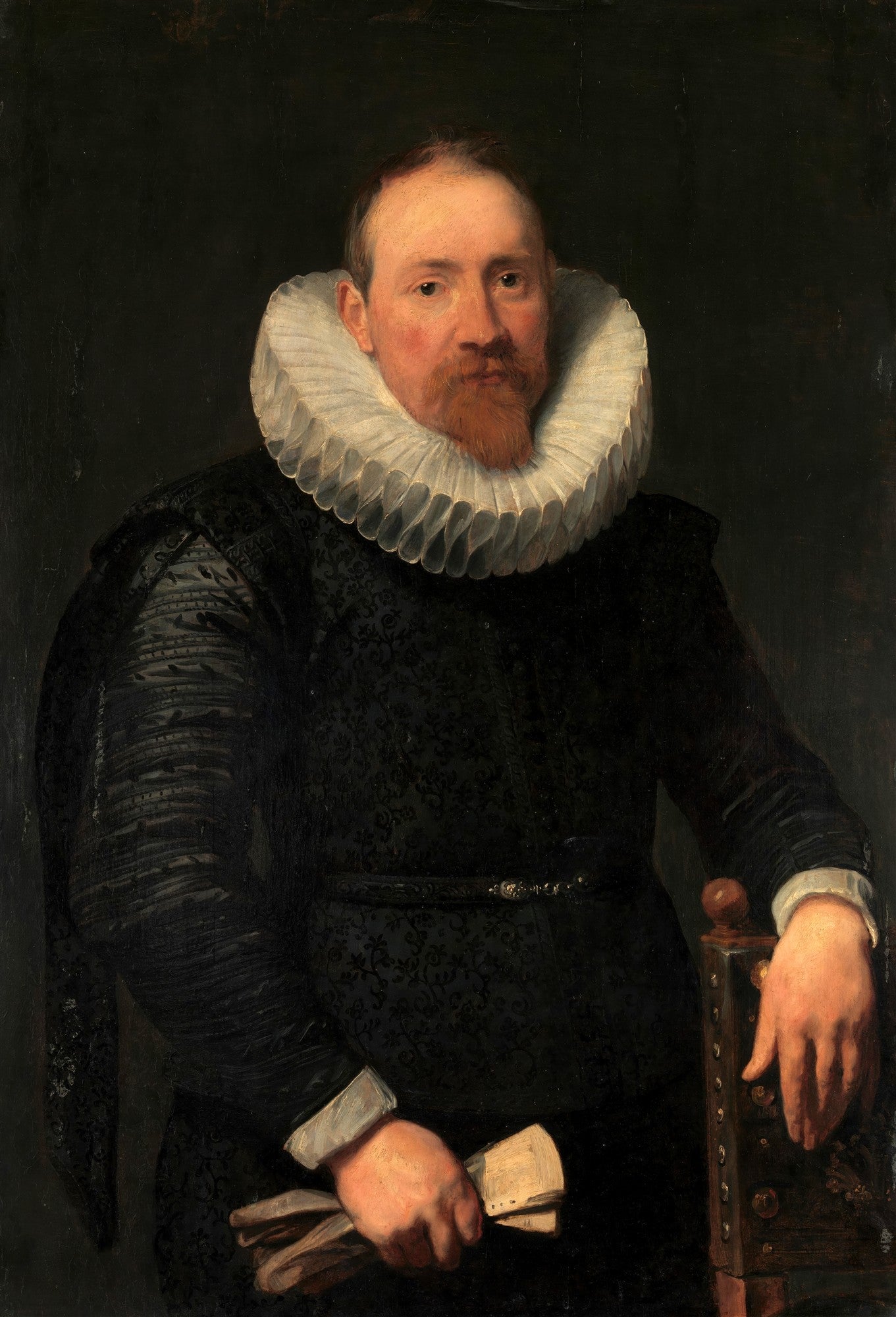 Retrato de um homem com barba ruiva e bigode, vestindo um traje preto ricamente detalhado e uma grande gola de rufos branca. Ele segura papéis na mão esquerda e apoia a direita em uma cadeira, com um fundo escuro.