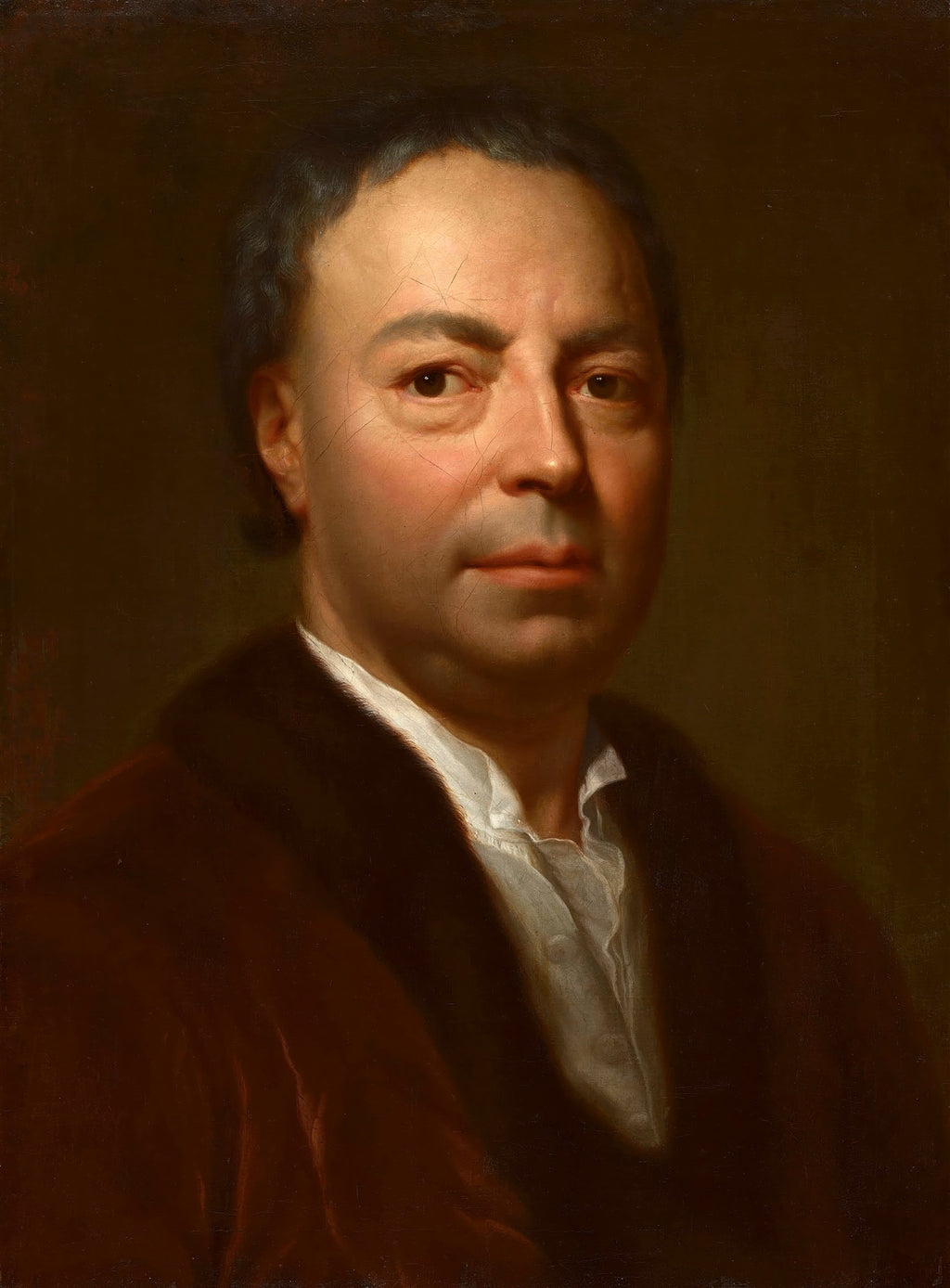Retrato de um homem de meia-idade, com cabelos escuros e ondulados, olhando diretamente para frente. Veste uma camisa branca com gola franzida e um casaco marrom escuro com gola de pele. A pele do rosto é clara, com tons rosados nas bochechas, e há algumas rachaduras visíveis na pintura antiga. O fundo é escuro e uniforme.