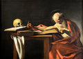 Quadro de São Jerônimo Escrevendo por Caravaggio, com o santo idoso debruçado sobre um livro, um crânio ao lado, iluminado por uma luz dramática.