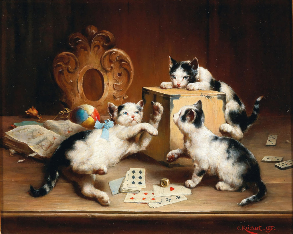 Quadro decorativo com três gatinhos preto e brancos brincando com cartas de baralho, um dado e uma bola em uma mesa de madeira. Um dos gatinhos está em cima de uma caixa, outro com uma fita azul está em pé e o terceiro está agachado. Ao fundo, um ornamento de madeira dourado e um livro aberto. A assinatura do artista C. Reichert e o ano 1890 são visíveis.