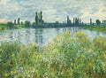 Quadro decorativo Campo de Papoulas em Argenteuil de Claude Monet, mostrando um rio e vegetação exuberante com flores brancas e amarelas em primeiro plano, sob um céu nublado e azul claro.
