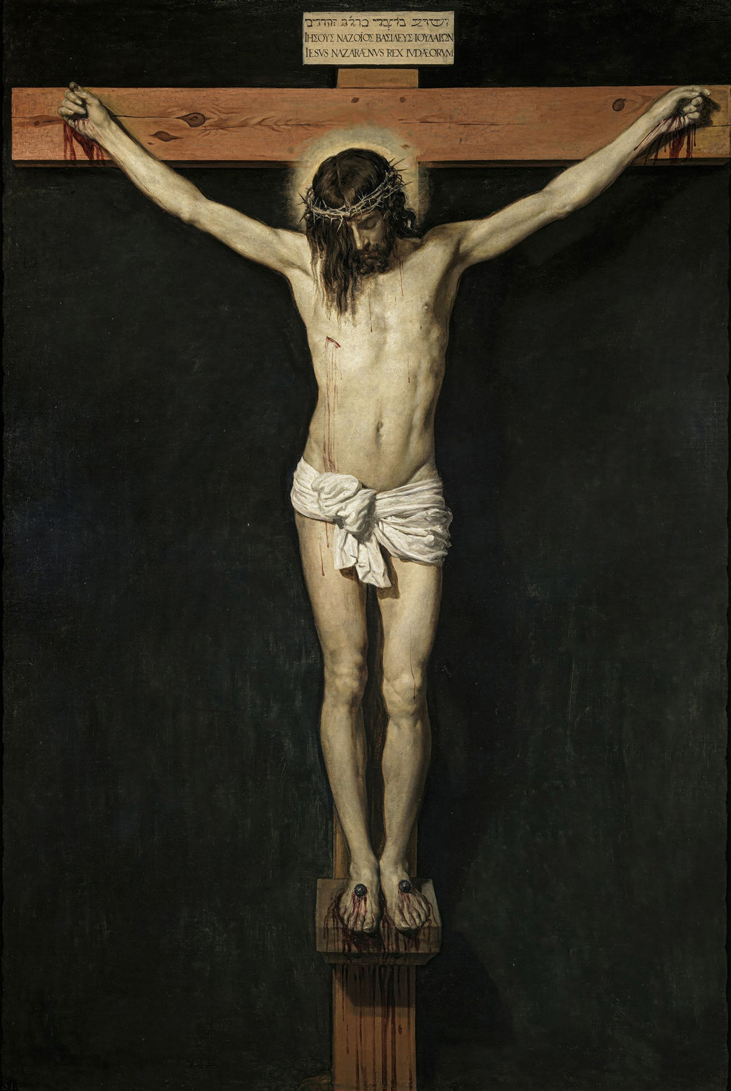 Quadro decorativo do Cristo Crucificado de Velázquez, apresentando a figura de Cristo pregado na cruz com um fundo escuro, destacando o corpo em tons claros e a coroa de espinhos, com sangue escorrendo nas mãos e pés.
