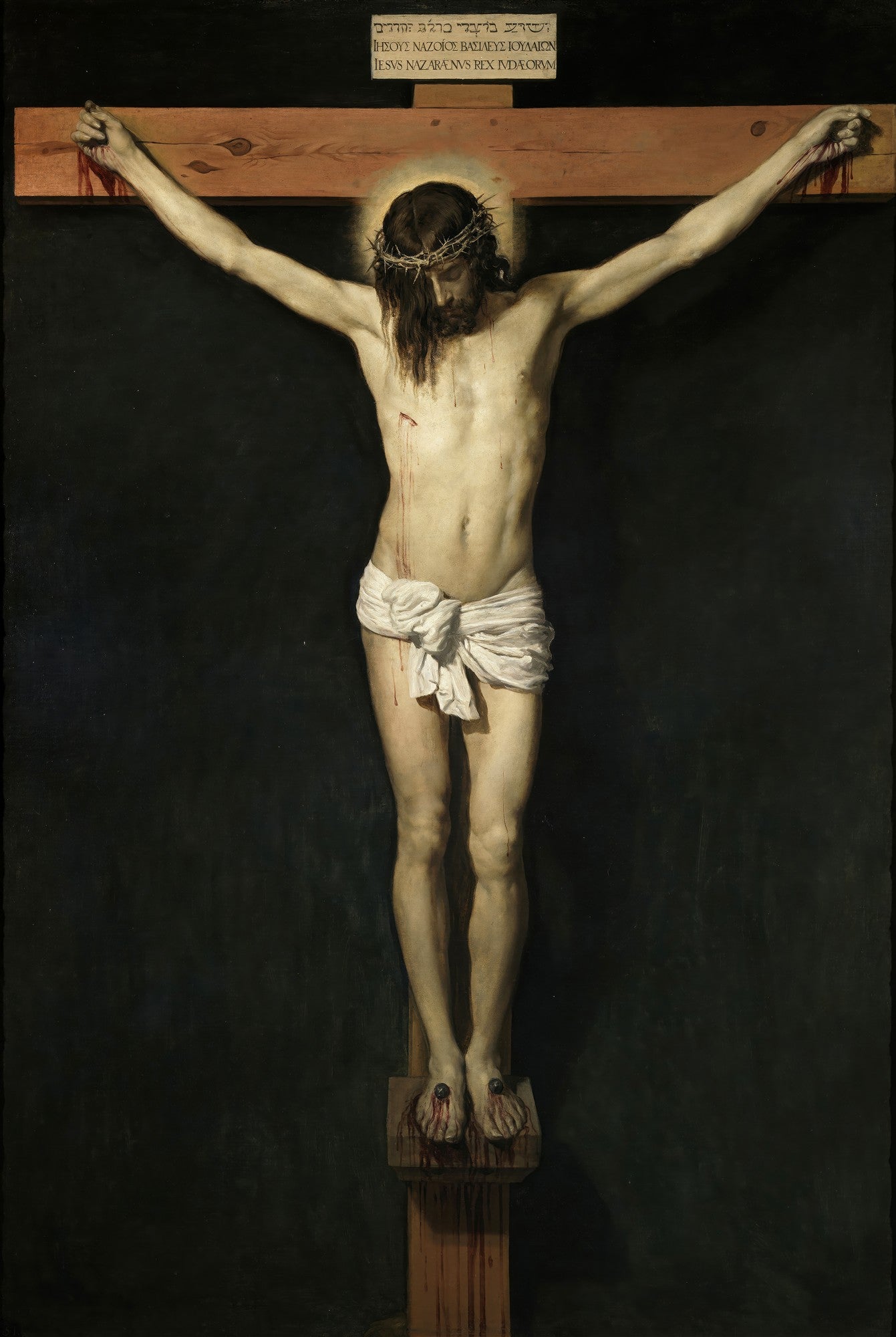 Quadro decorativo com a obra Cristo Crucificado de Diego Velázquez, mostrando Jesus na cruz com um pano branco e fundo escuro. A imagem é detalhada e transmite serenidade e dor.
