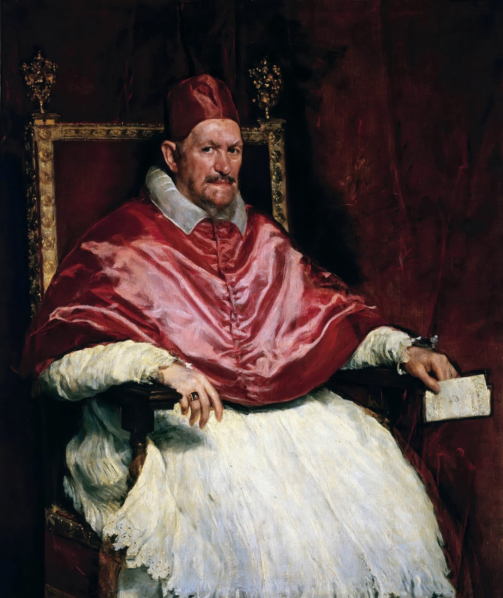 Retrato em óleo de Diego Velázquez mostrando o Papa Inocêncio X, um homem de meia-idade com barba, vestindo vestes papais vermelhas, sentado em uma cadeira ornamentada, com um olhar penetrante