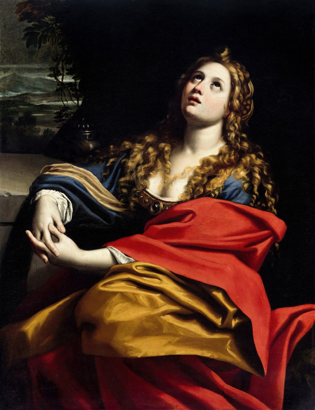 Quadro decorativo da Madalena Penitente, obra de Domenichino. Mulher com cabelos cacheados e roupas vermelhas e azuis, olhando para cima com expressão de súplica, mãos unidas. Fundo escuro com paisagem sutil à esquerda.