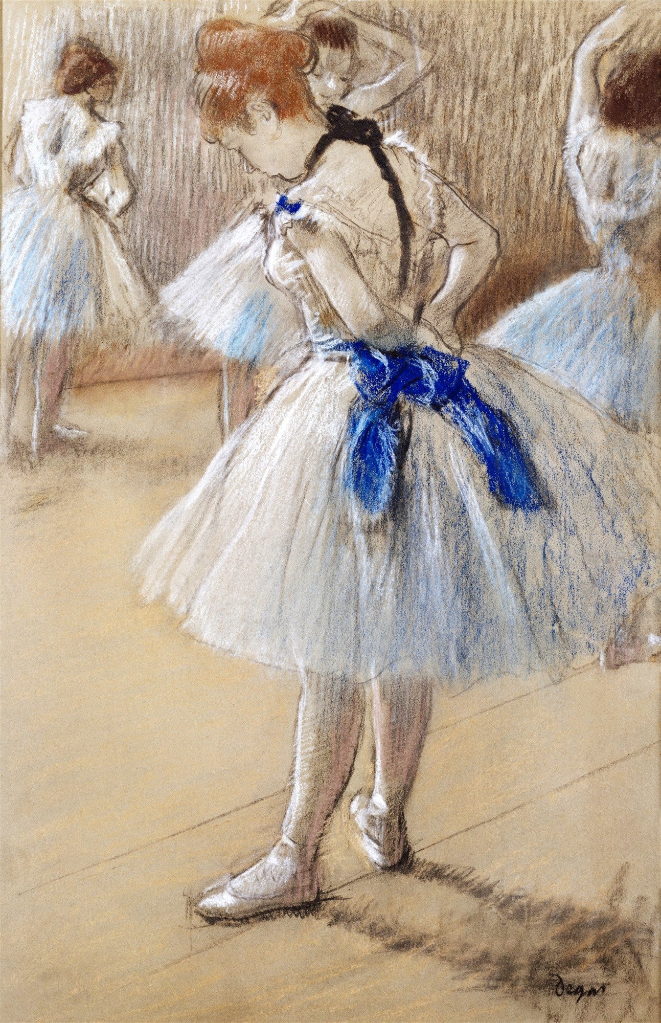 Quadro decorativo mostrando três bailarinas em uma sala de ensaio. A bailarina em primeiro plano, de costas, amarra uma fita azul em sua cintura, com um tutu branco. As outras duas bailarinas estão ao fundo, uma se arrumando e outra em posição de espera.