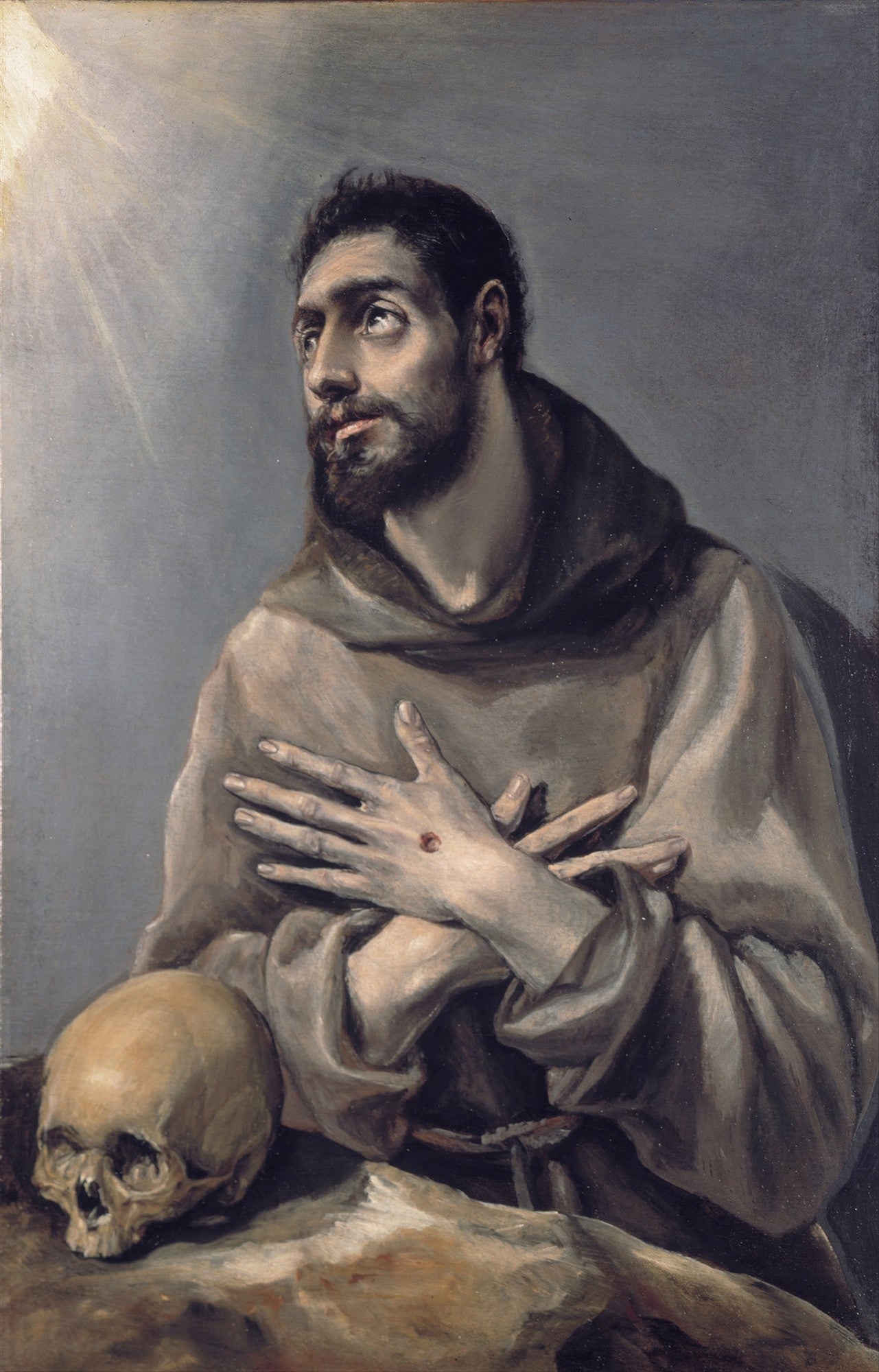 Quadro decorativo mostrando São Francisco de Assis em oração, com a mão sobre o peito exibindo uma chaga e um crânio ao seu lado. A luz divina irradia do canto superior esquerdo. Estilo clássico, com tons sombrios e dramáticos, típico de El Greco.