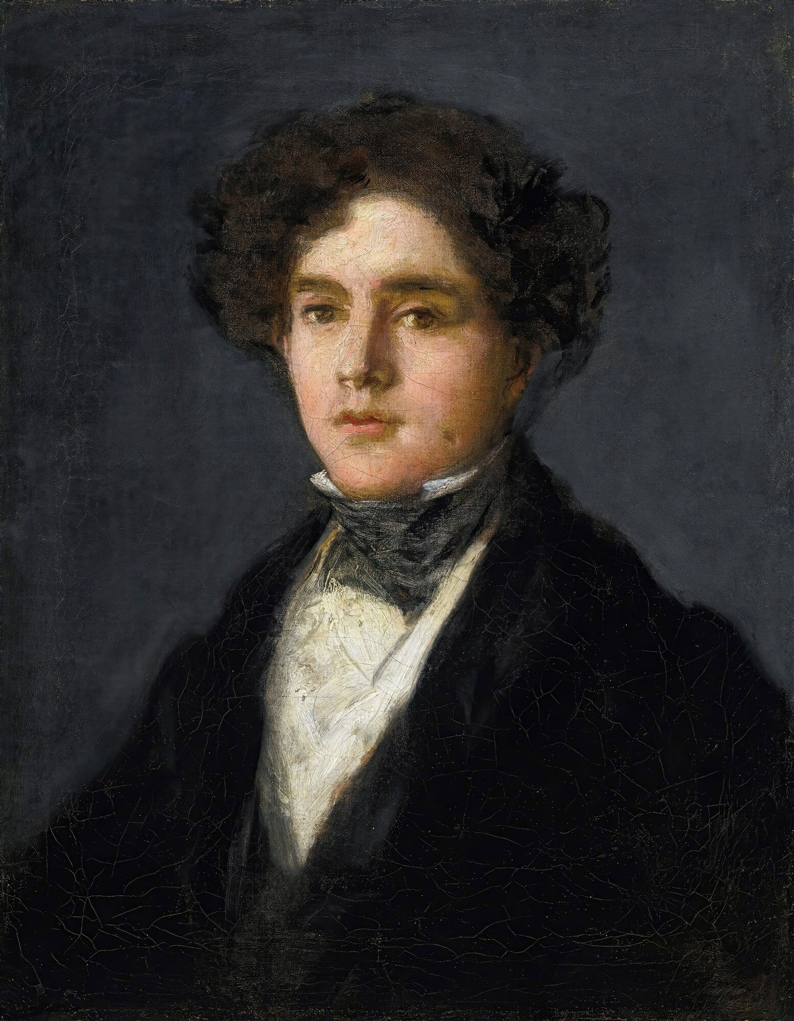 Retrato de um jovem de cabelos escuros e ondulados, vestindo um casaco escuro e camisa branca, com olhar direto e expressivo, em fundo cinza-escuro. Obra atribuída a Francisco de Goya.