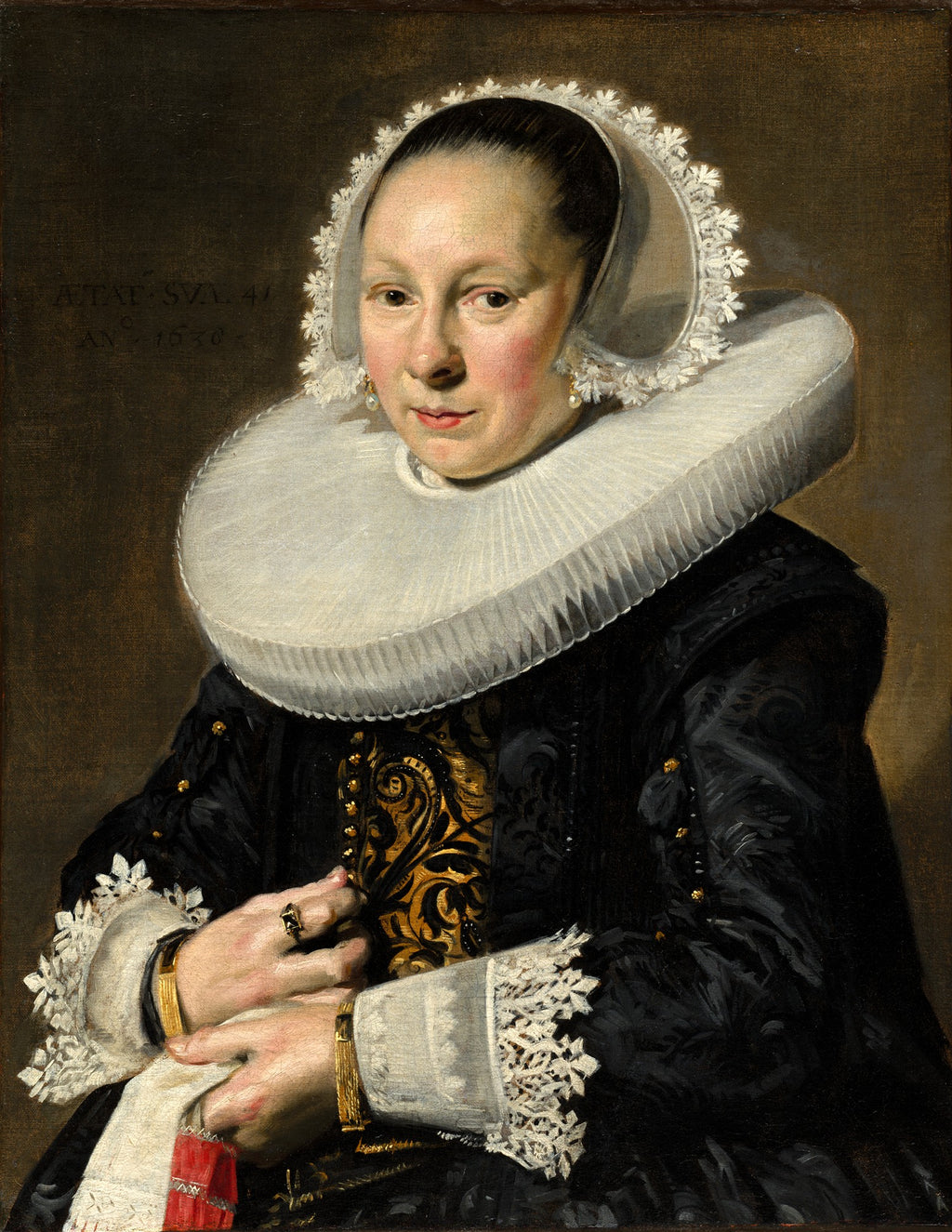 Retrato de uma mulher da Idade de Ouro Holandesa, com touca de renda branca, gola plissada grande e vestes escuras com detalhes dourados. A mulher tem um olhar sereno e mãos delicadamente cruzadas. A obra é atribuída a Frans Hals.