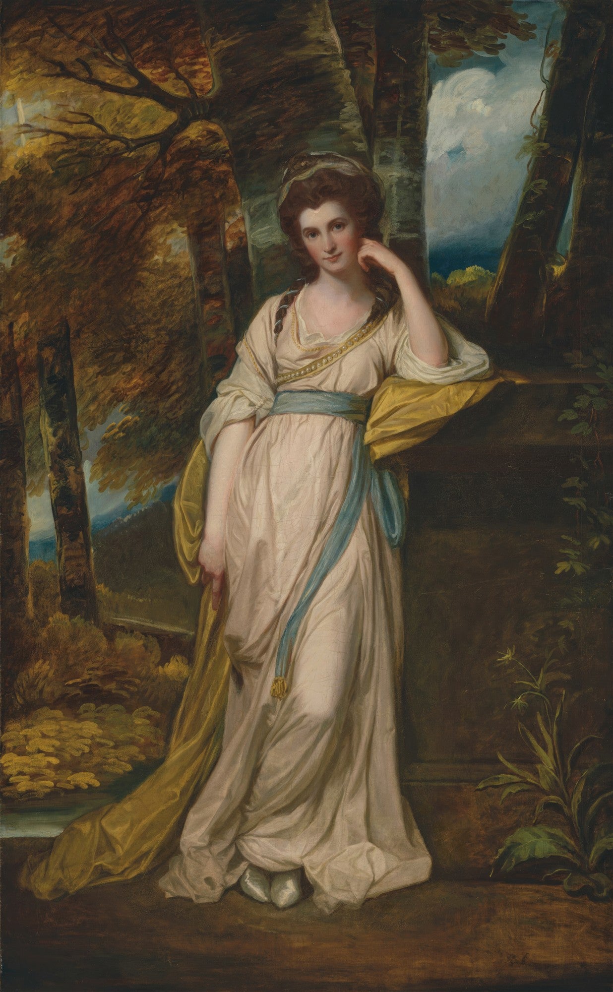 Retrato de corpo inteiro de uma mulher em vestes clássicas, apoiada em um pedestal, em meio a uma paisagem arborizada. A mulher tem cabelos castanhos, pele clara e um olhar sereno. Usa um vestido creme com detalhes em azul e dourado. A luz incide suavemente sobre ela.