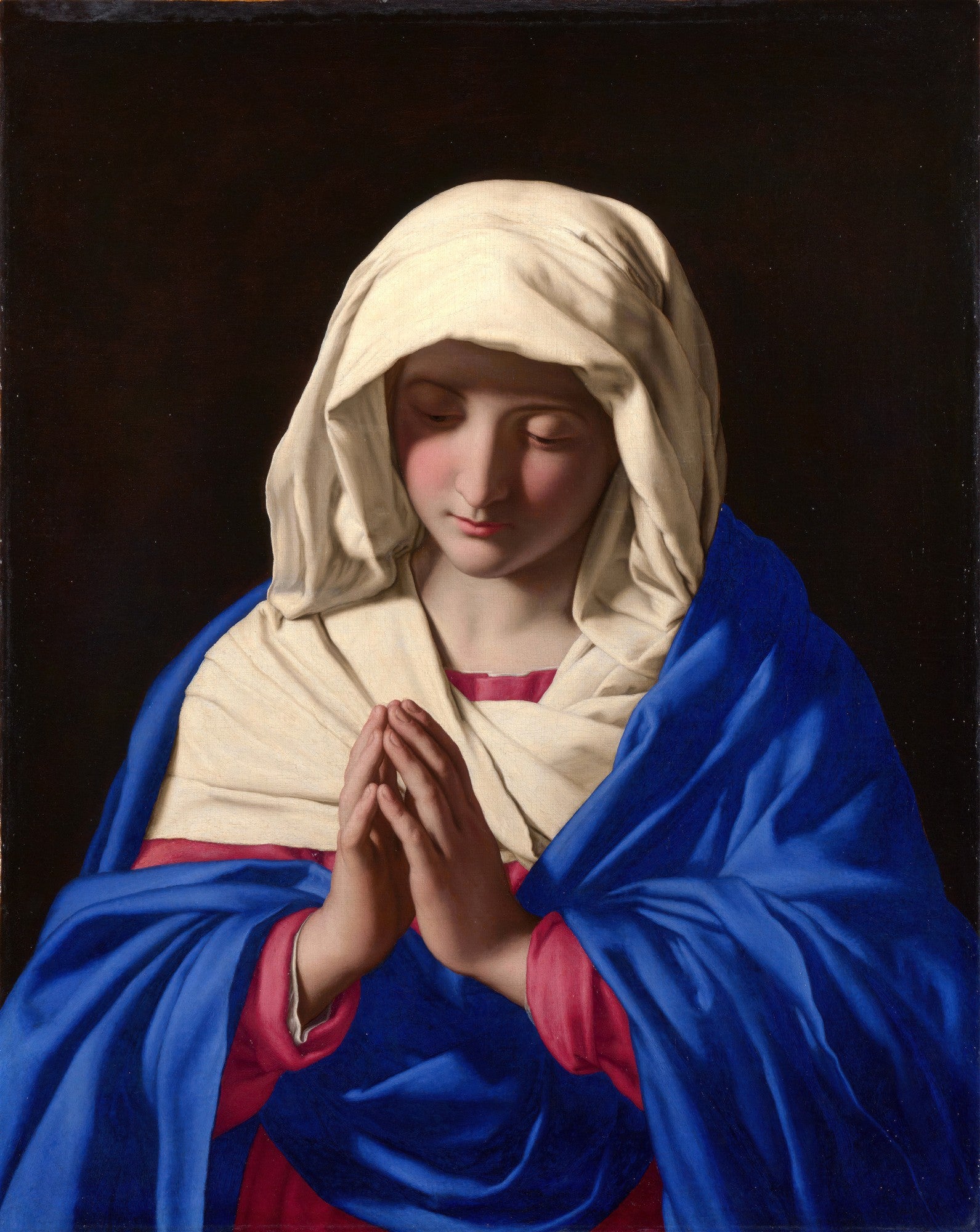 Quadro decorativo 'A Virgem em Oração' de Sassoferrato, retratando a Virgem Maria com vestes azuis e brancas, mãos postas em oração e semblante sereno, sobre fundo escuro.