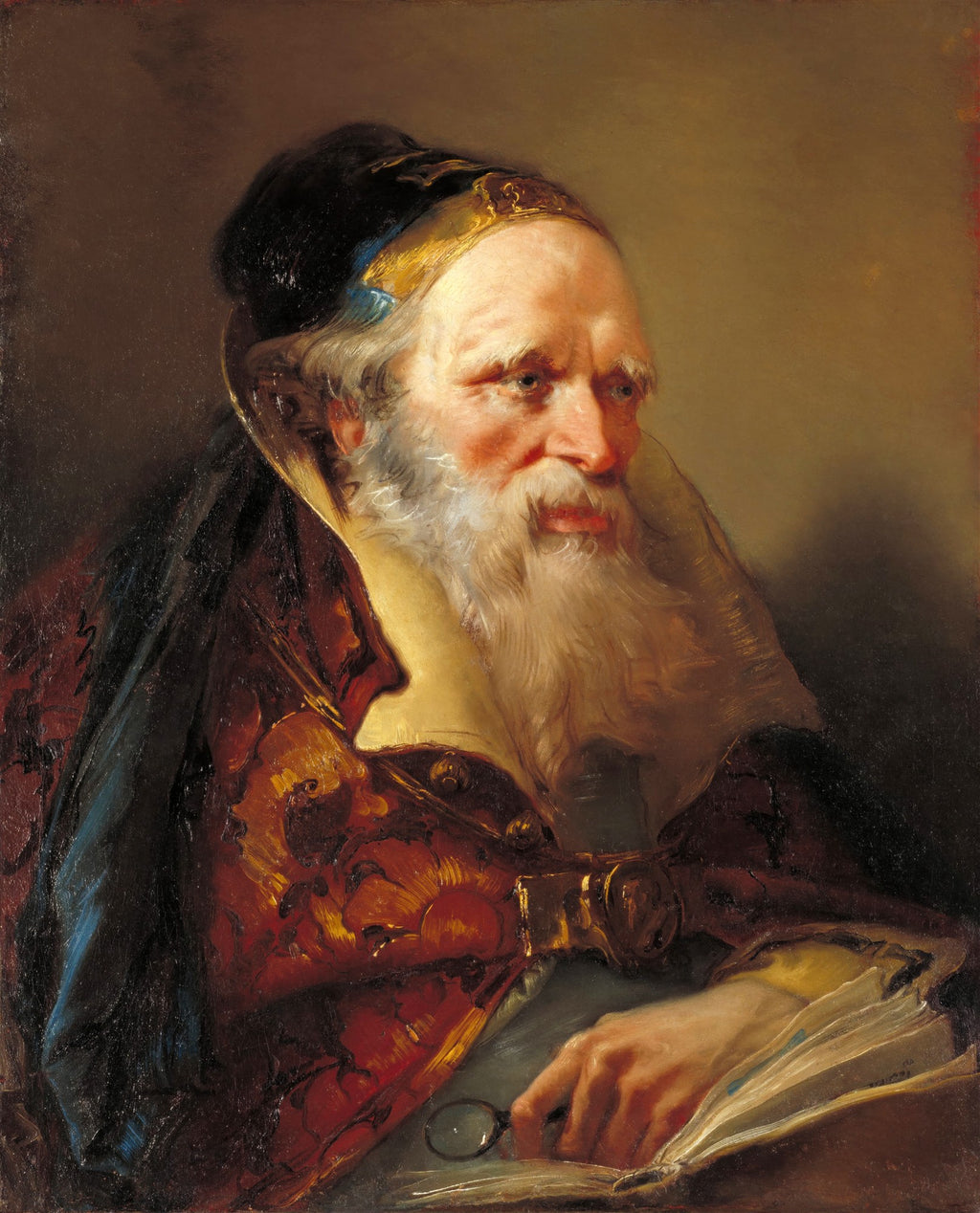 Retrato de um homem idoso com barba branca longa, chapéu escuro com detalhe dourado, vestindo um manto ornamentado em tons de vermelho e dourado, segurando um livro aberto e um monóculo. A luz incide sobre seu rosto pensativo.