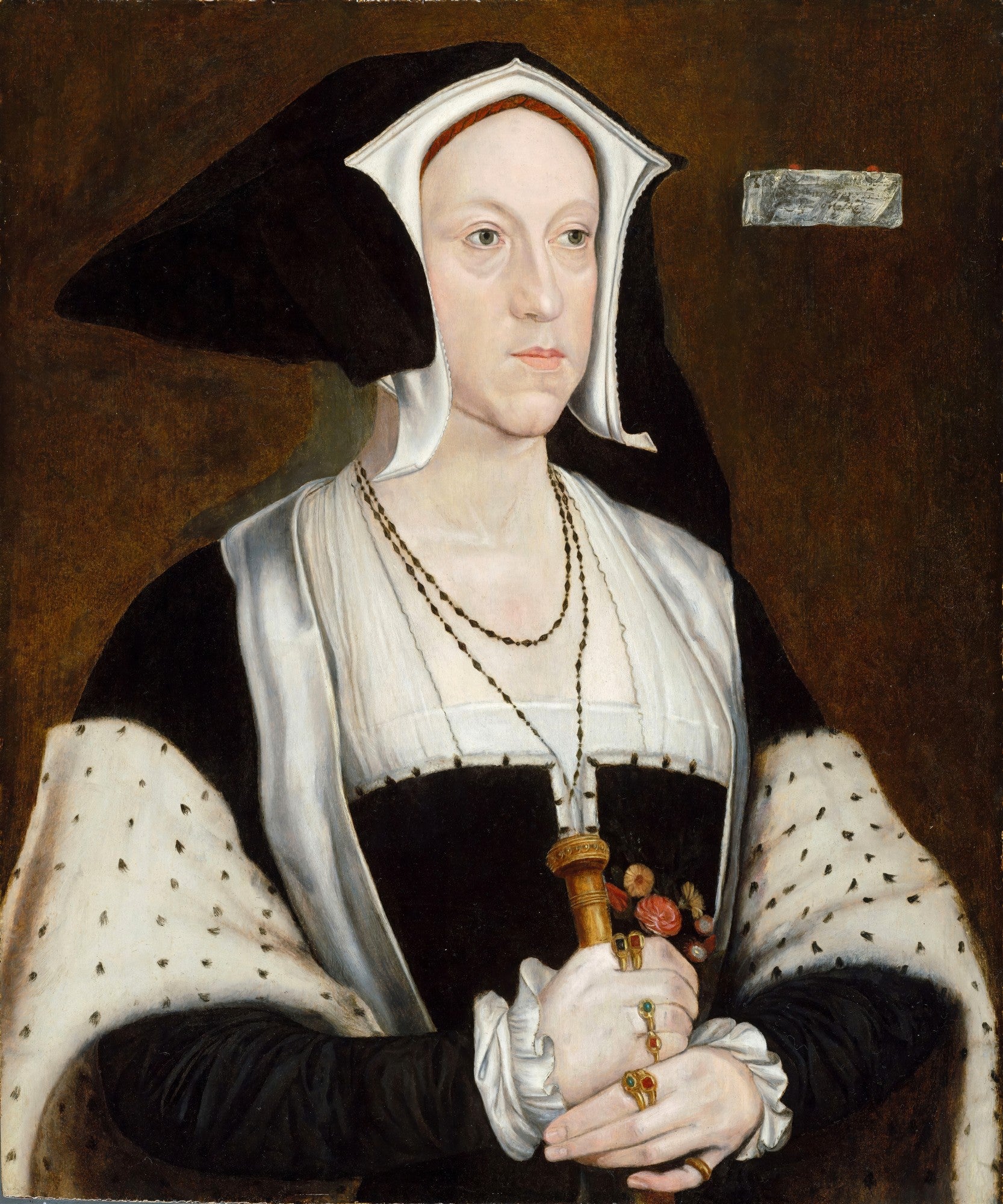 Retrato de Anna de Cleves, pintado por Hans Holbein, exibindo uma mulher com touca preta e branca, roupas escuras e joias discretas, segurando um objeto, com um fundo marrom escuro.