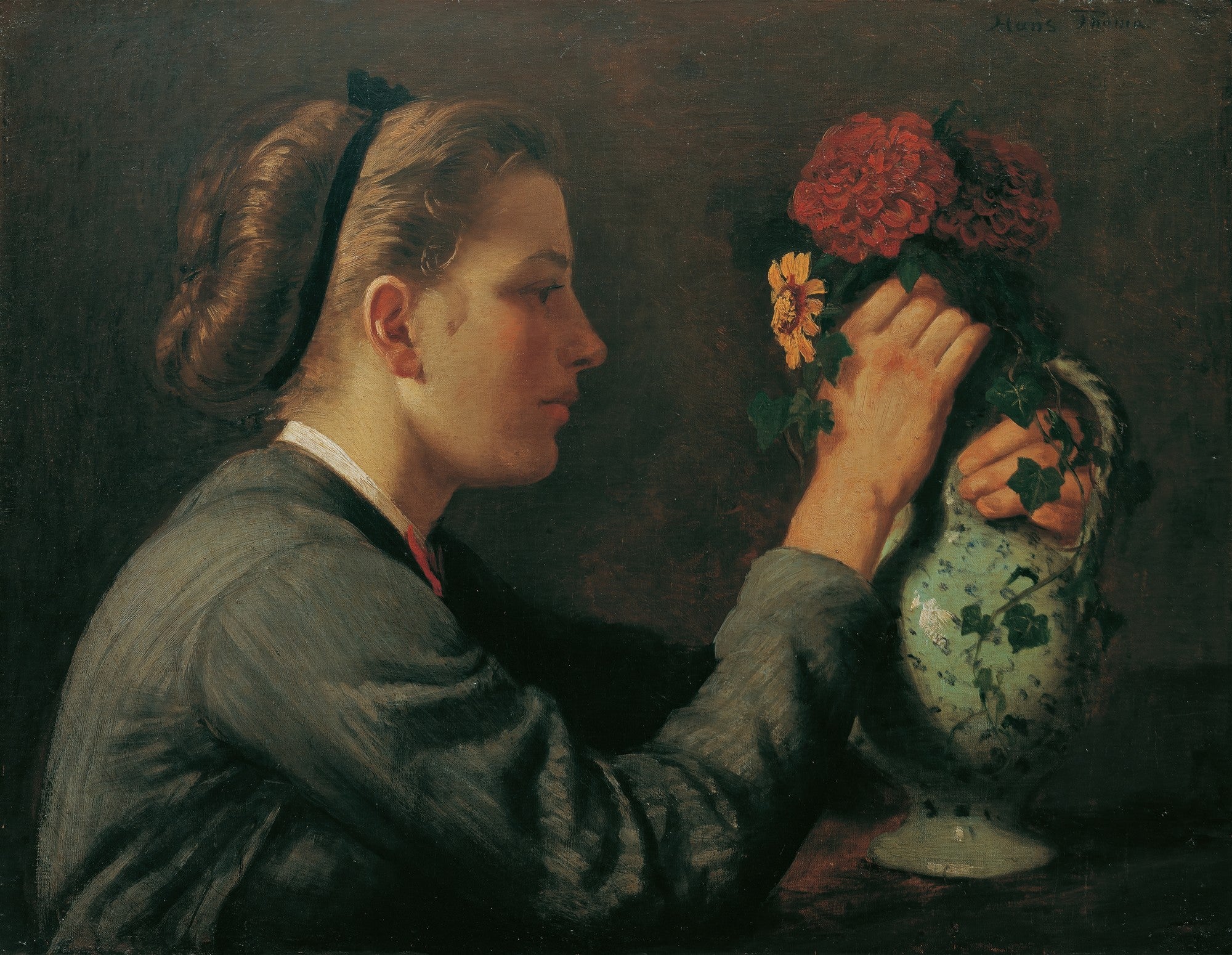 Uma jovem de perfil com uma fita preta no cabelo, observando e arrumando flores vermelhas e amarelas em um vaso decorado com hera. O fundo é escuro.
