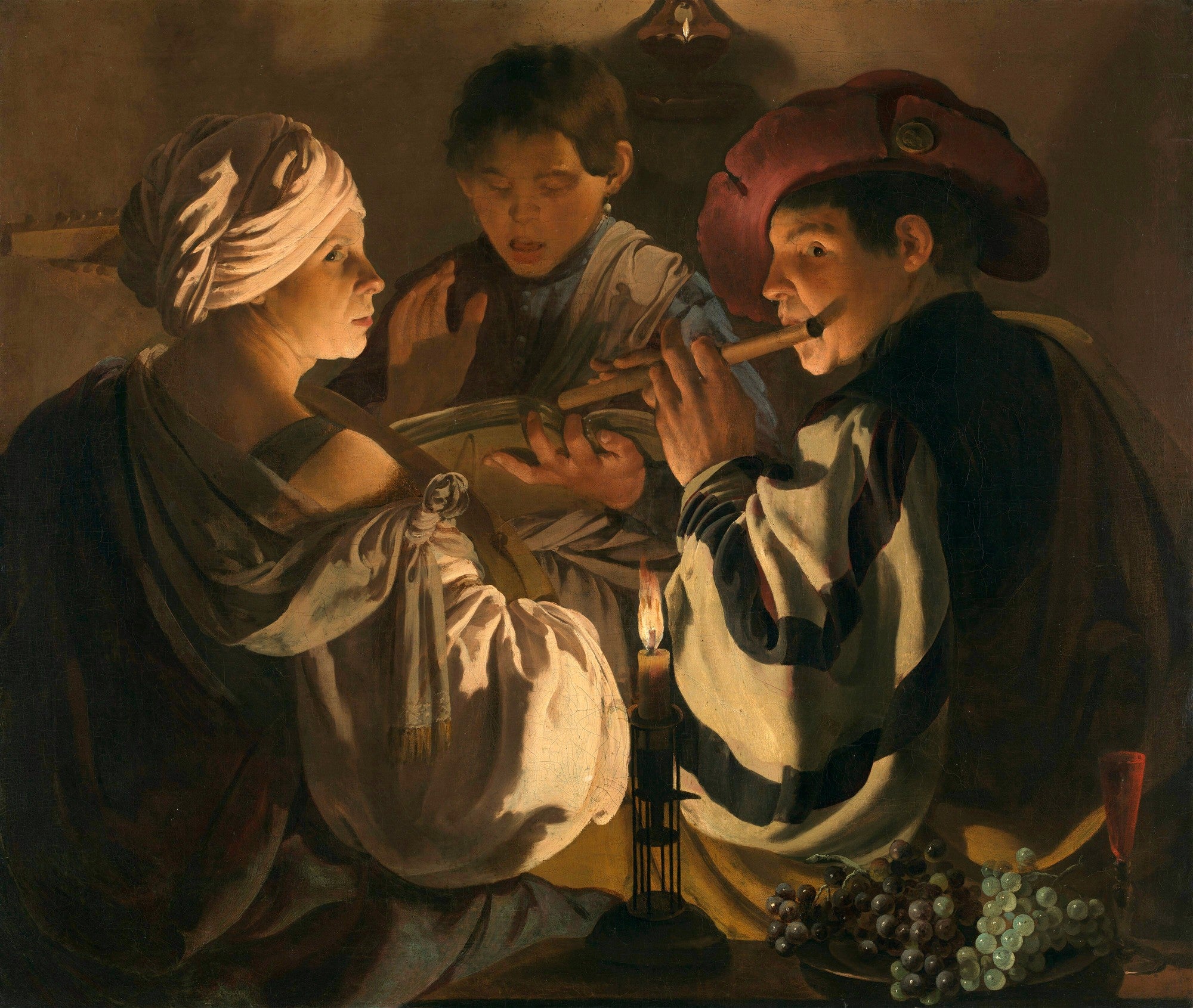 Quadro decorativo "A Concerto Noturno" de Hendrick ter Brugghen, mostrando três figuras em torno de uma vela, com um tocador de flauta, um cantor e uma mulher observando, em um ambiente escuro iluminado pela luz da vela. As figuras estão vestidas com roupas da época barroca e há uvas na mesa.