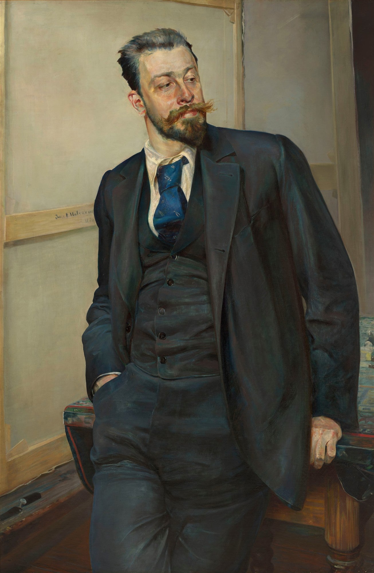 Retrato de corpo inteiro de um homem com bigode e barba ruivos, vestindo terno escuro e gravata azul, assinado por Jacek Malczewski.