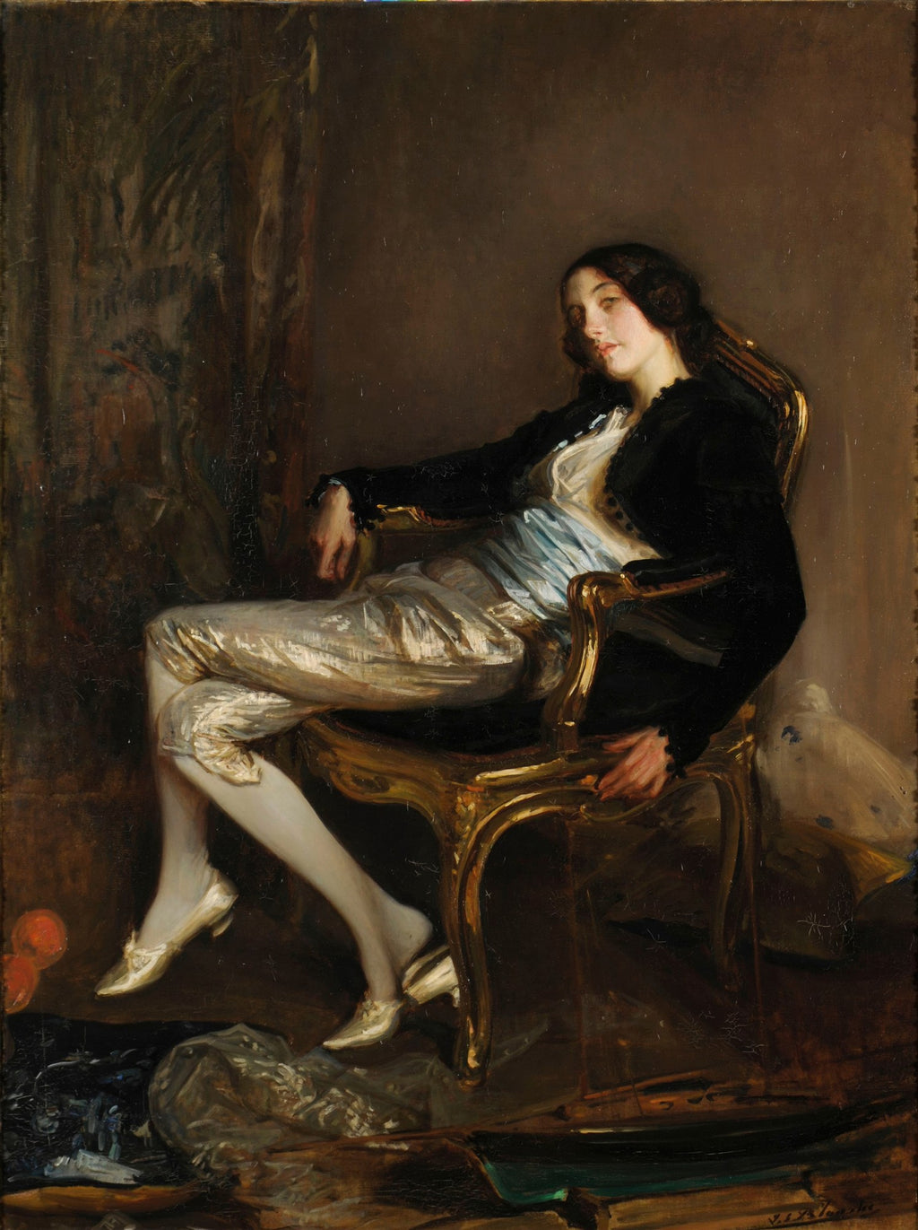 Retrato de mulher reclinada em cadeira dourada, vestindo calças douradas e jaqueta preta. A obra é de Jacques Émile Blanche e possui um estilo clássico com iluminação dramática.