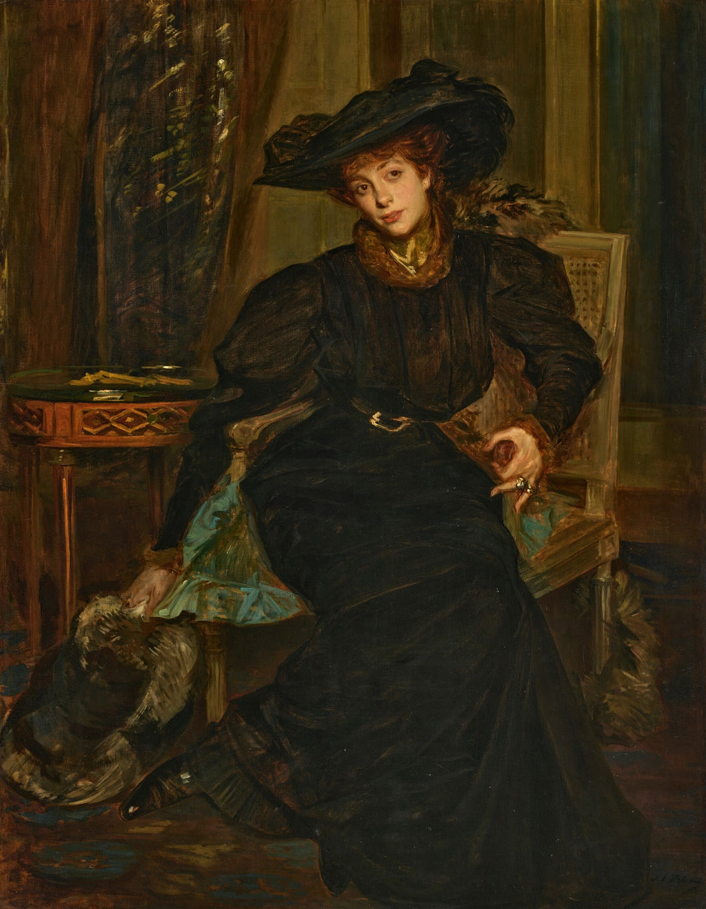 Retrato de uma mulher sentada, vestindo um chapéu grande e um vestido escuro, em um ambiente de época com detalhes em madeira e tecido. A mulher tem cabelos ruivos e um olhar pensativo.
