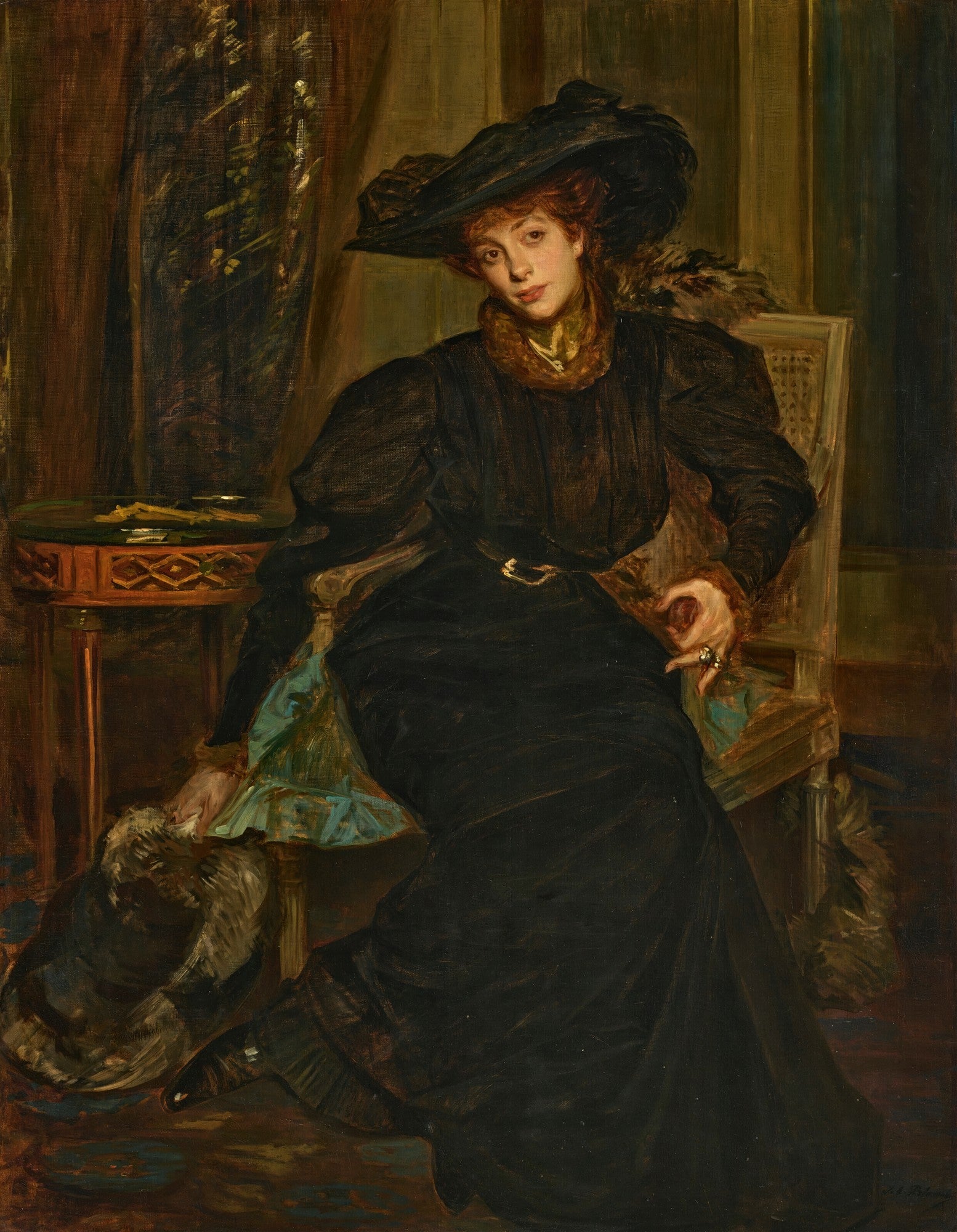 Retrato de uma mulher sentada, vestindo um chapéu grande e um vestido escuro, em um ambiente de época com detalhes em madeira e tecido. A mulher tem cabelos ruivos e um olhar pensativo.