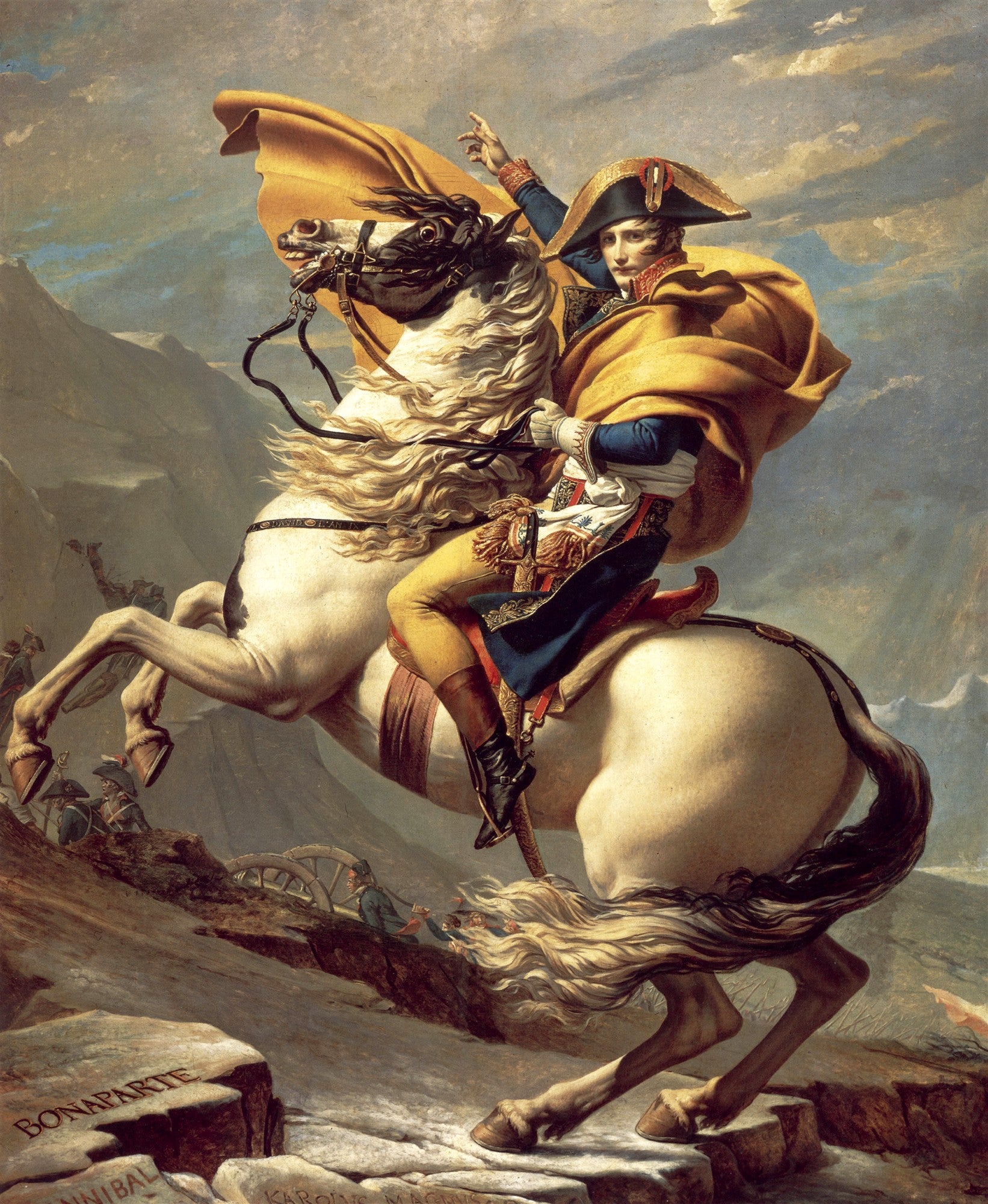 Quadro decorativo de Napoleão Bonaparte montado em um cavalo branco empinado, atravessando os Alpes. Ele veste uniforme militar e uma capa amarela esvoaçante, apontando para o alto, com uma expressão determinada. O fundo mostra montanhas rochosas e um céu nublado, com soldados e canhões à distância, simbolizando a travessia épica.