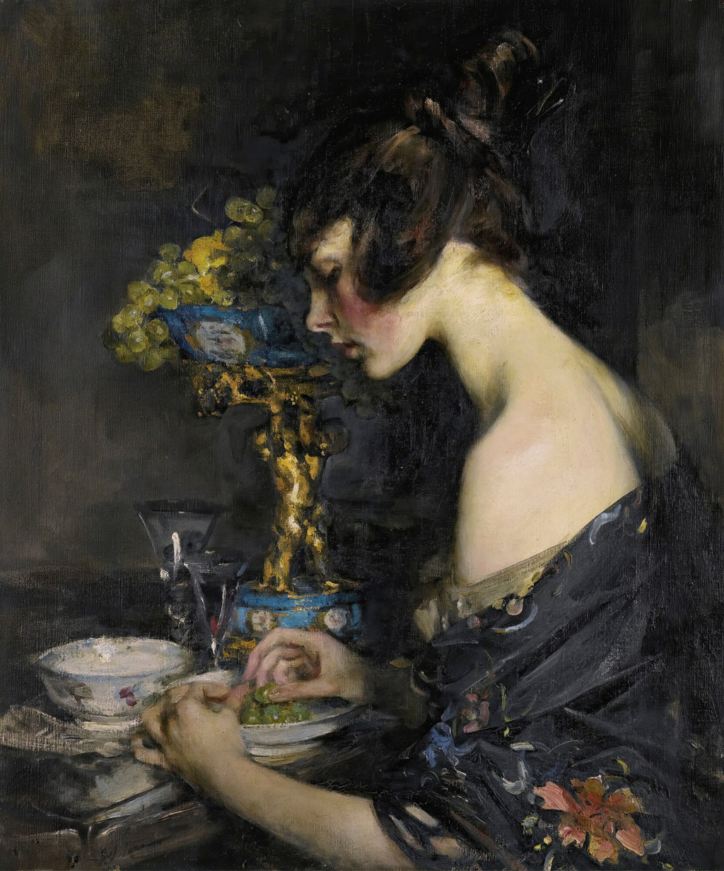 Quadro decorativo mostrando uma mulher sentada em perfil, vestindo um robe escuro florido, comendo uvas de um prato. Ao lado, um vaso dourado com mais uvas. A cena é escura e íntima, com foco na figura feminina e nos detalhes.