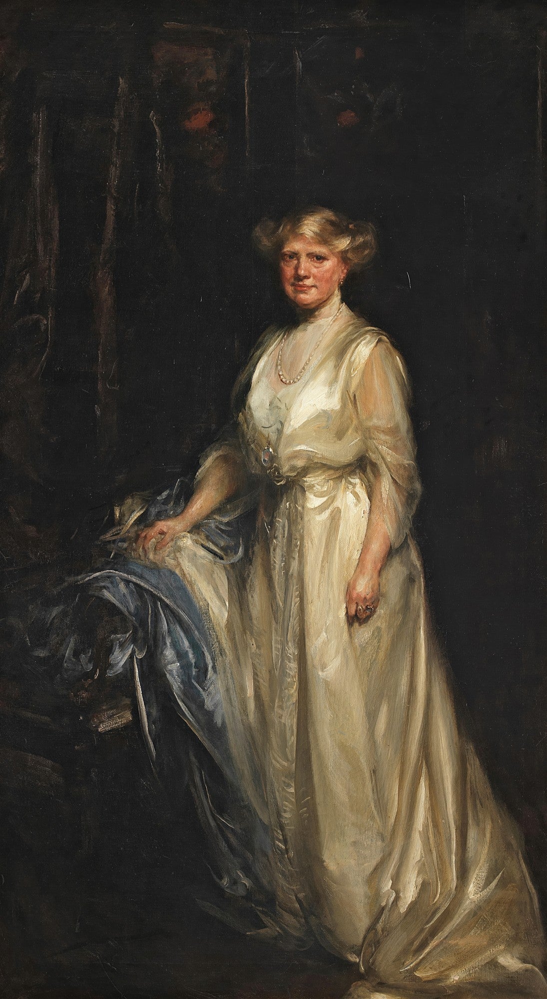 Retrato em óleo de uma mulher de meia-idade, loira, em pé, vestindo um vestido de seda creme ou branco, com um colar de pérolas, sobre um fundo escuro. A mão esquerda dela repousa sobre um tecido azul. A iluminação é dramática, destacando o rosto e o vestido.