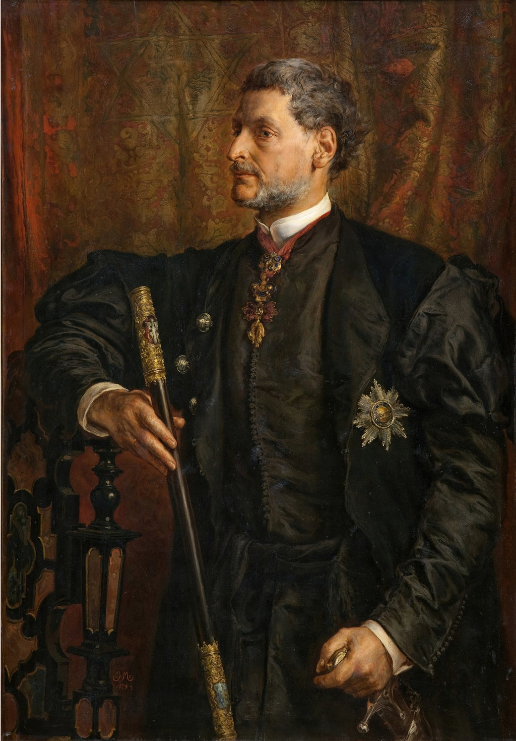 Retrato a óleo de um cavalheiro com barba e cabelos grisalhos, vestindo um casaco escuro com insígnias e segurando uma bengala ornamentada, sobre um fundo de tapeçaria em tons de vermelho e dourado. A assinatura 'J.M. 1869' é visível no canto inferior esquerdo.