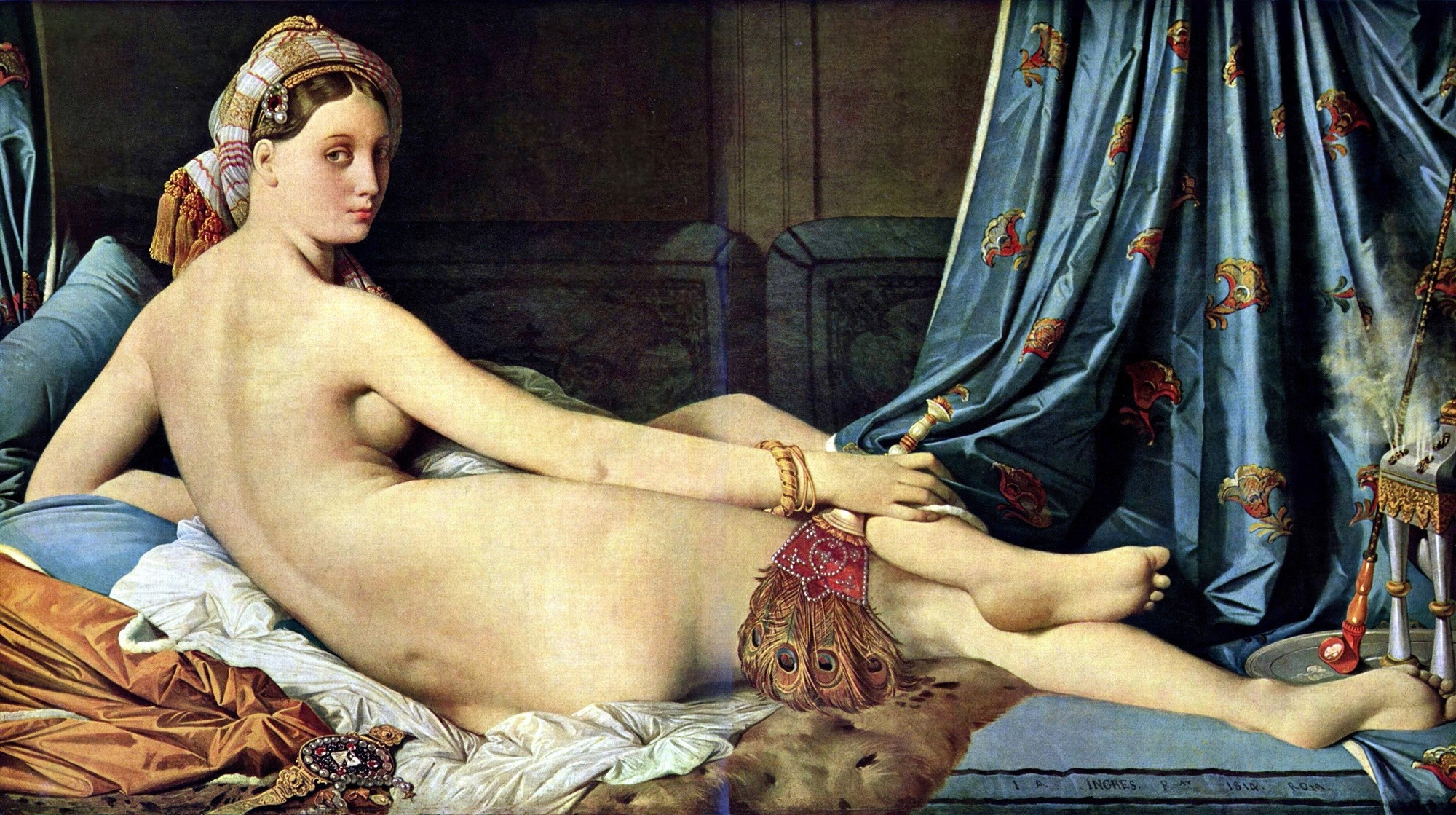 Pintura a óleo de Jean-Auguste-Dominique Ingres, uma odalisca nua deitada de costas para o observador, com a cabeça virada para a frente. Ela usa um turbante e está cercada por tecidos luxuosos, como uma cortina azul com padrões dourados e sedas em tons de marrom e branco. Um leque de penas de pavão está em sua mão.