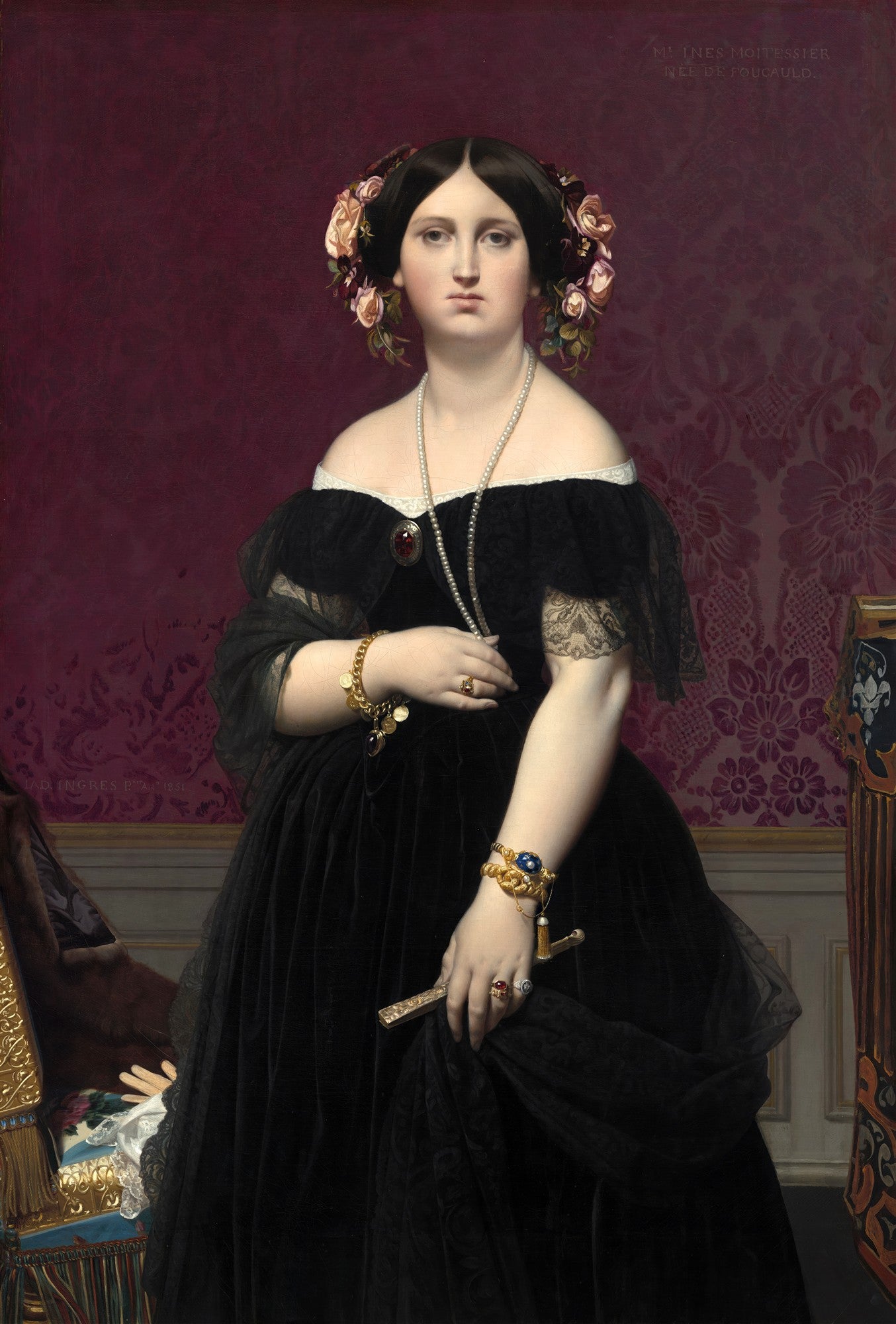 Retrato de Madame Moitessier por Ingres, mulher sentada de frente, vestindo um vestido preto de veludo com decote ombro a ombro, joias douradas e pérolas, cabelo escuro adornado com flores, fundo em tom de vinho com padrões. Ela segura um leque.