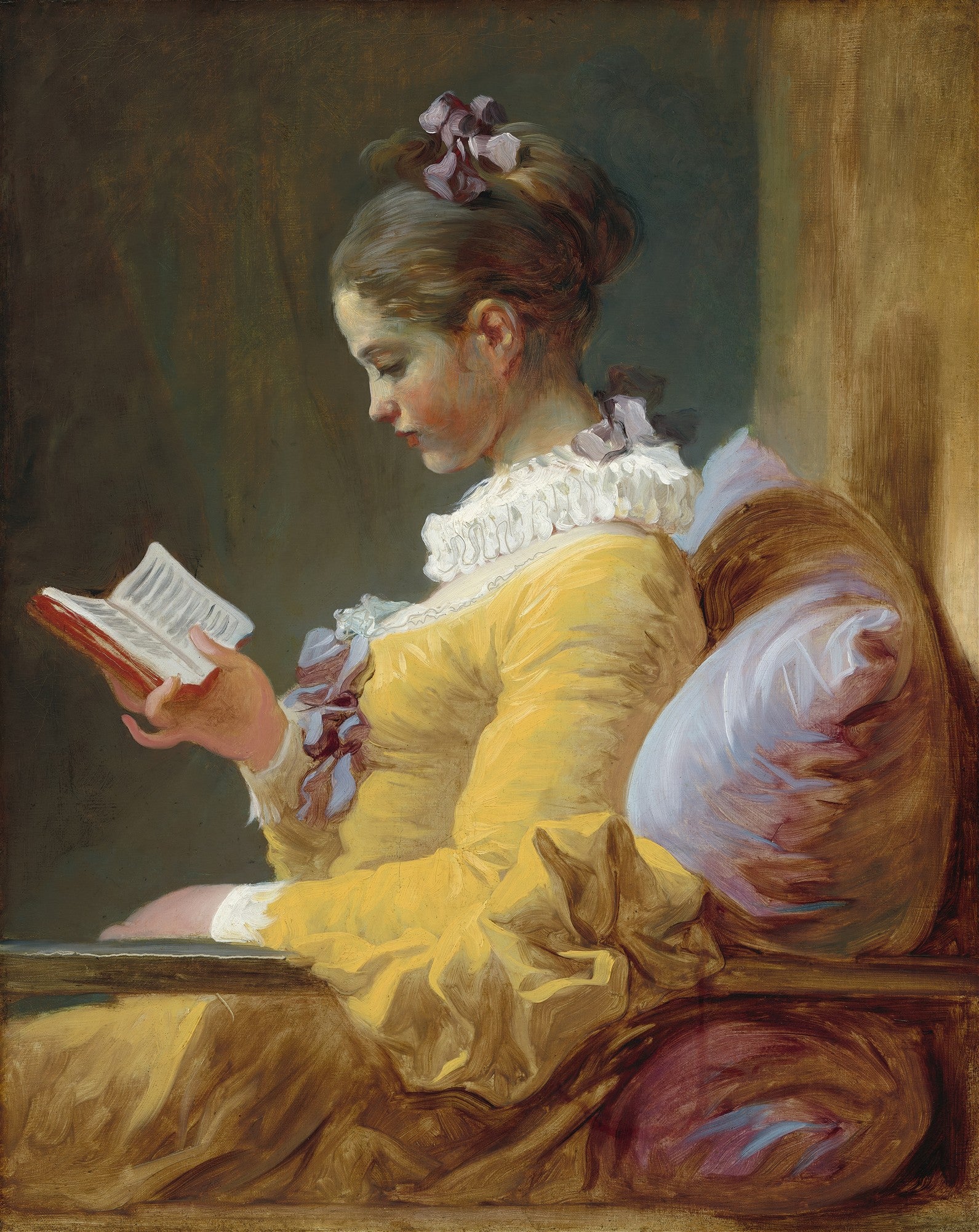 Pintura de Jean-Honoré Fragonard, 'A Leitora', retratando uma jovem mulher de perfil, vestindo um vestido amarelo vibrante e gola branca, absorta na leitura de um livro. Seu cabelo castanho está preso com um laço lilás e ela está sentada em um ambiente aconchegante com almofadas.