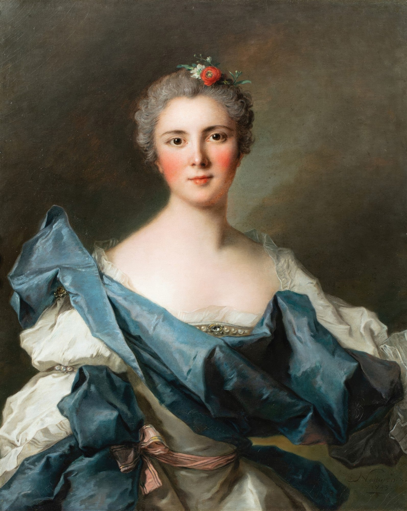 Retrato de uma jovem mulher com cabelos cinzentos presos e uma flor vermelha no cabelo, vestindo um vestido branco com drapeados azuis e detalhes em joias, com um fundo escuro. A obra é de Jean Marc Nattier, datada de 1749.