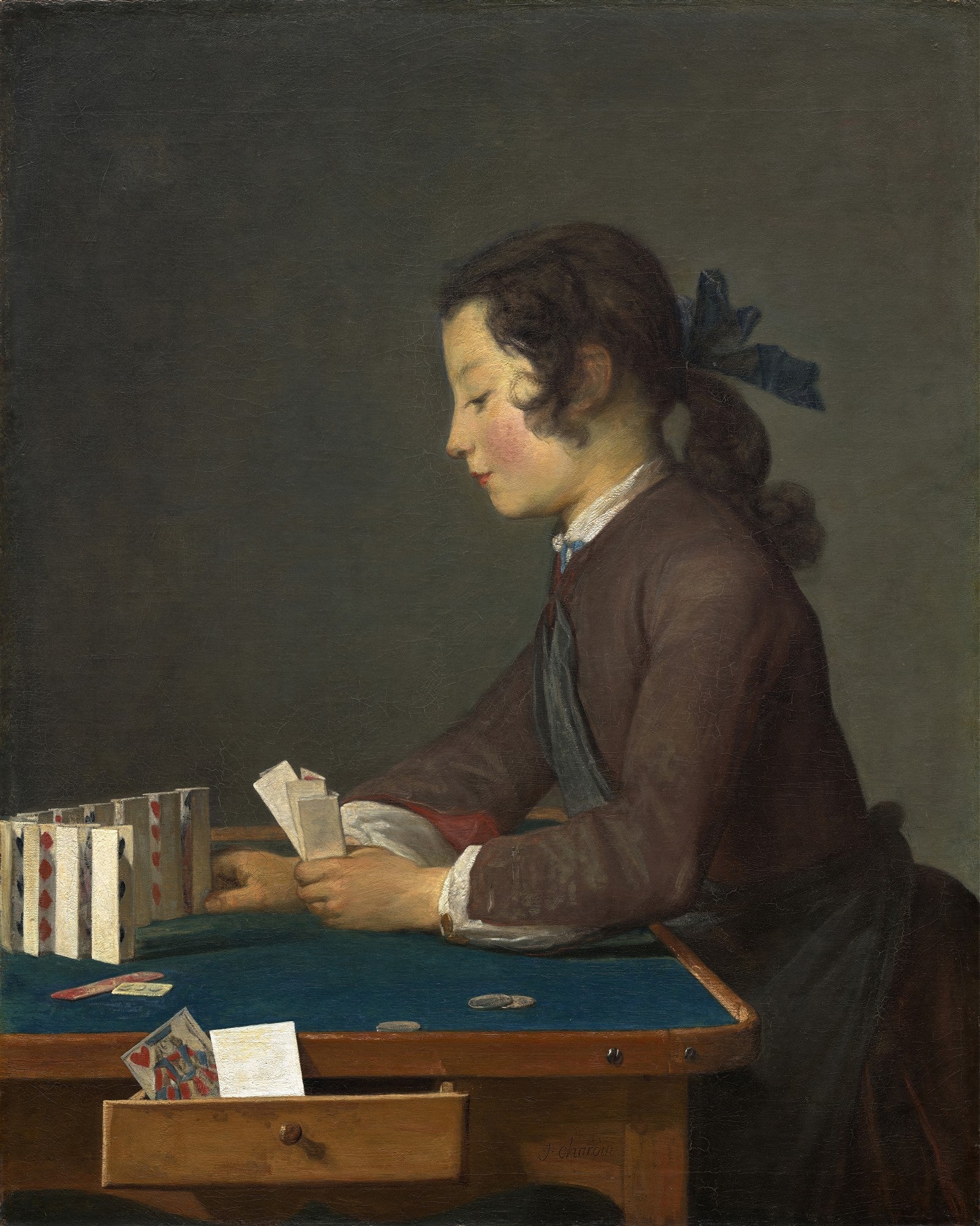 Pintura a óleo de Jean Siméon Chardin retratando um jovem absorto na construção de um castelo de cartas sobre uma mesa verde, em perfil.