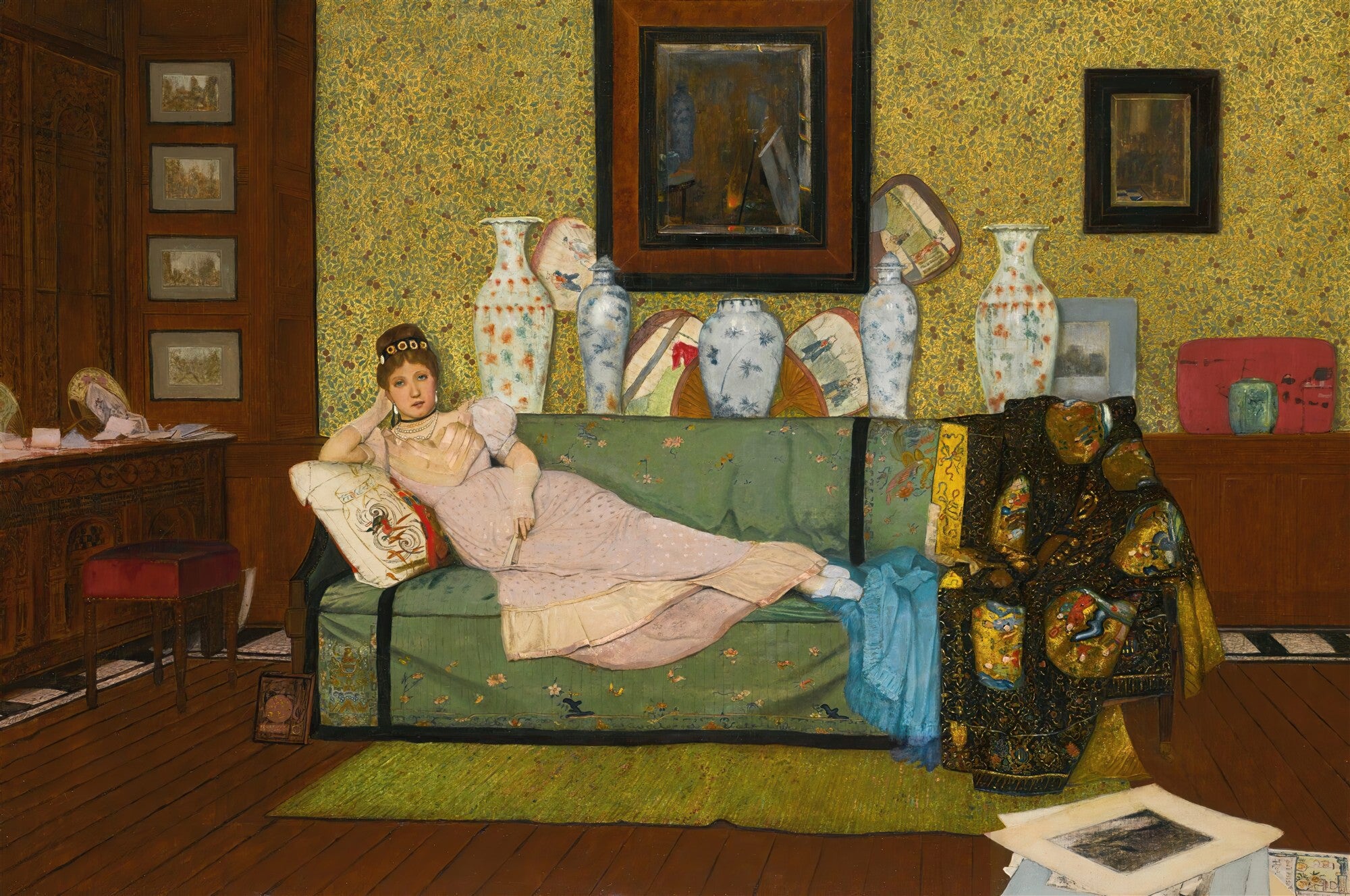 Quadro decorativo "A Dama do Sofá", atribuído a John Atkinson Grimshaw, apresentando uma mulher reclinada em um sofá verde em um interior ricamente decorado com papel de parede amarelo, vasos orientais e móveis de madeira.