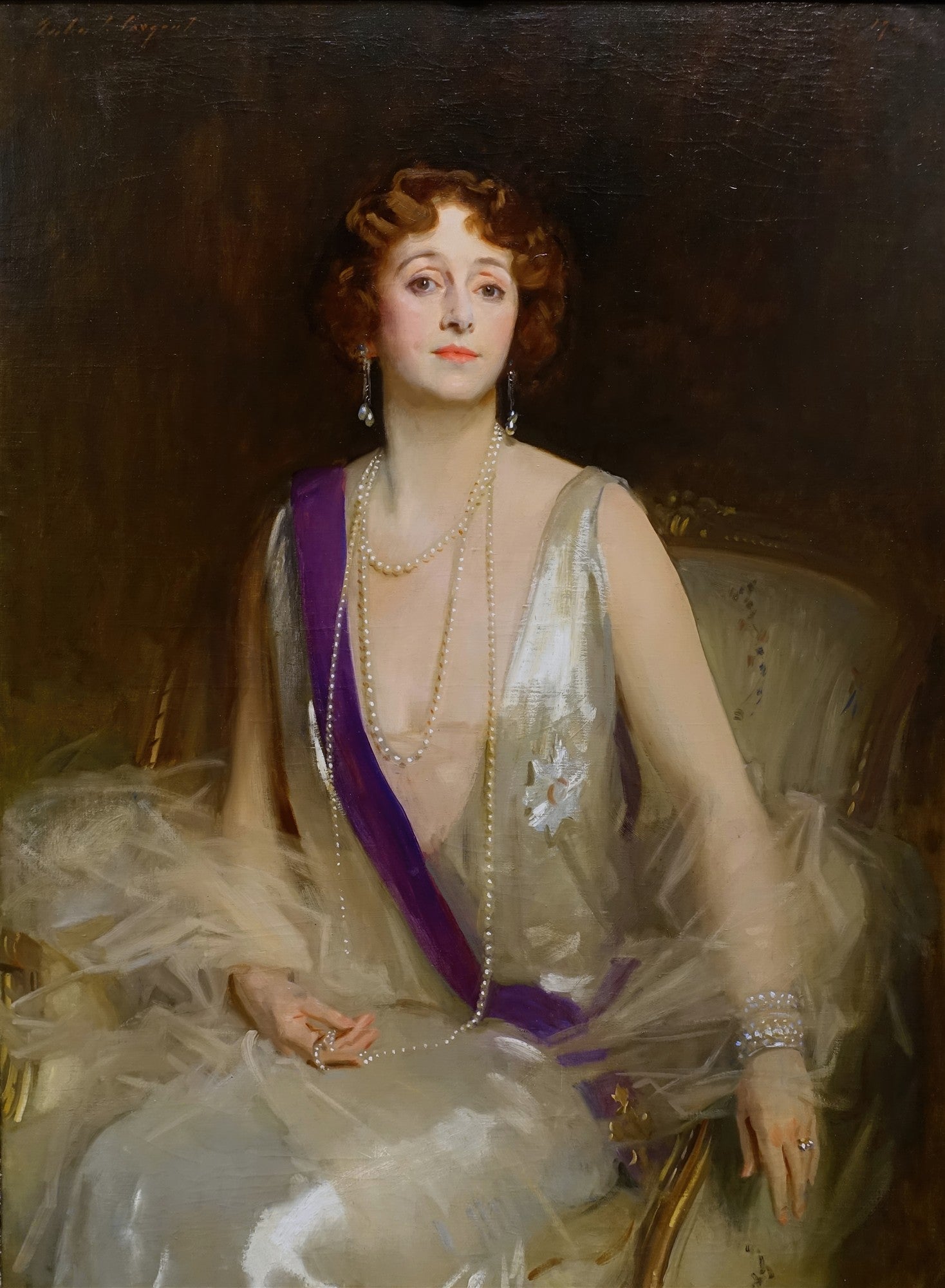 Retrato a óleo de Lady Curzon por John Singer Sargent, mostrando uma mulher com cabelo ruivo, colar de pérolas, vestido branco e faixa roxa, sentada em uma cadeira elegante