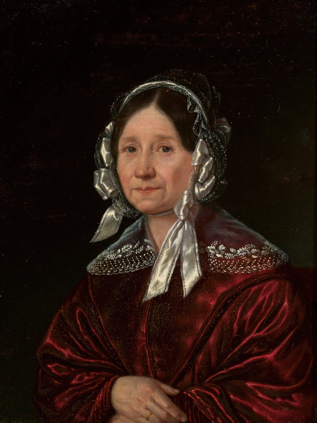 Retrato de uma senhora idosa com um toucado branco e preto, vestindo um robe de veludo vermelho e um anel dourado no dedo, com fundo escuro. Obra atribuída a Józef Simmler.