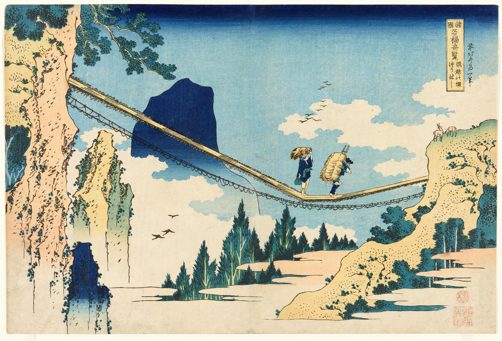Gravura japonesa colorida de Katsushika Hokusai, 'A Ponte Suspensa de Hoki', mostrando duas figuras atravessando uma ponte rústica de madeira e cordas entre montanhas íngremes, sob um céu azul claro com nuvens brancas, e árvores verdes escuras no vale.