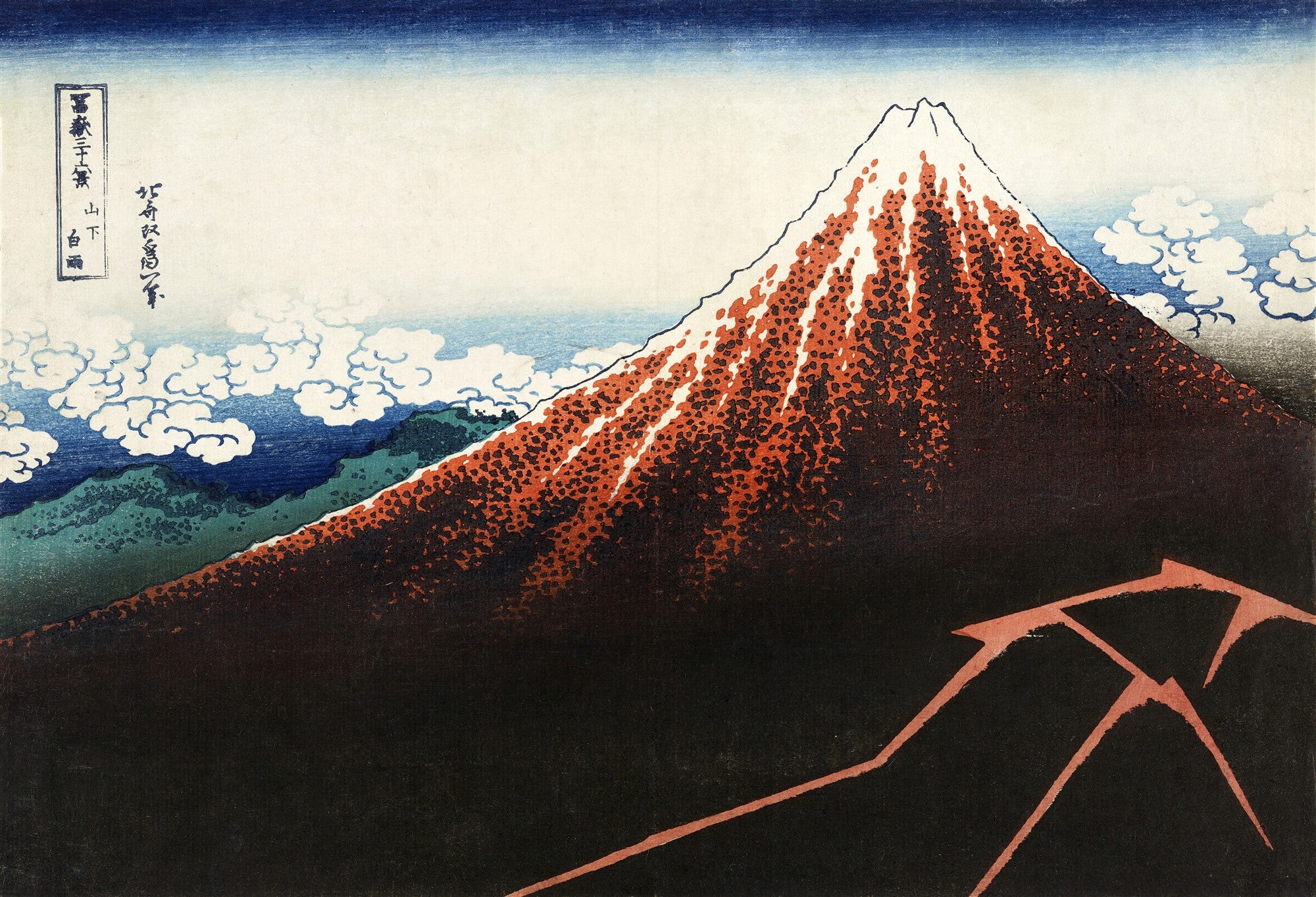 Gravura japonesa colorida de Katsushika Hokusai, mostrando o Monte Fuji em tons de vermelho e laranja sob um céu azul escuro com nuvens brancas. A montanha tem neve branca no topo e uma base escura, com vegetação verde e azul na encosta inferior esquerda. Detalhes de texto em japonês estão no canto superior esquerdo.