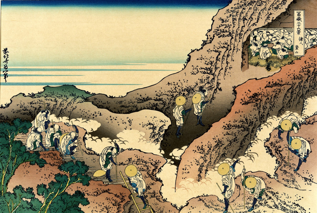Xilogravura japonesa de Katsushika Hokusai, 'Peregrinos Escalando o Monte Fuji'. Homens com chapéus de palha e cajados sobem uma montanha rochosa com vegetação e nuvens, em direção a um abrigo no topo. O céu e o oceano ao fundo são azuis e claros.