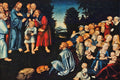 Pintura 'A Multiplicação dos Pães' de Lucas Cranach, o Velho, mostrando Jesus e seus discípulos alimentando uma multidão, com destaque para a figura de Jesus e um menino com peixes e pães. A cena é ambientada em um campo verde escuro com árvores ao fundo e um céu azul anil, com muitas pessoas e um cachorro.