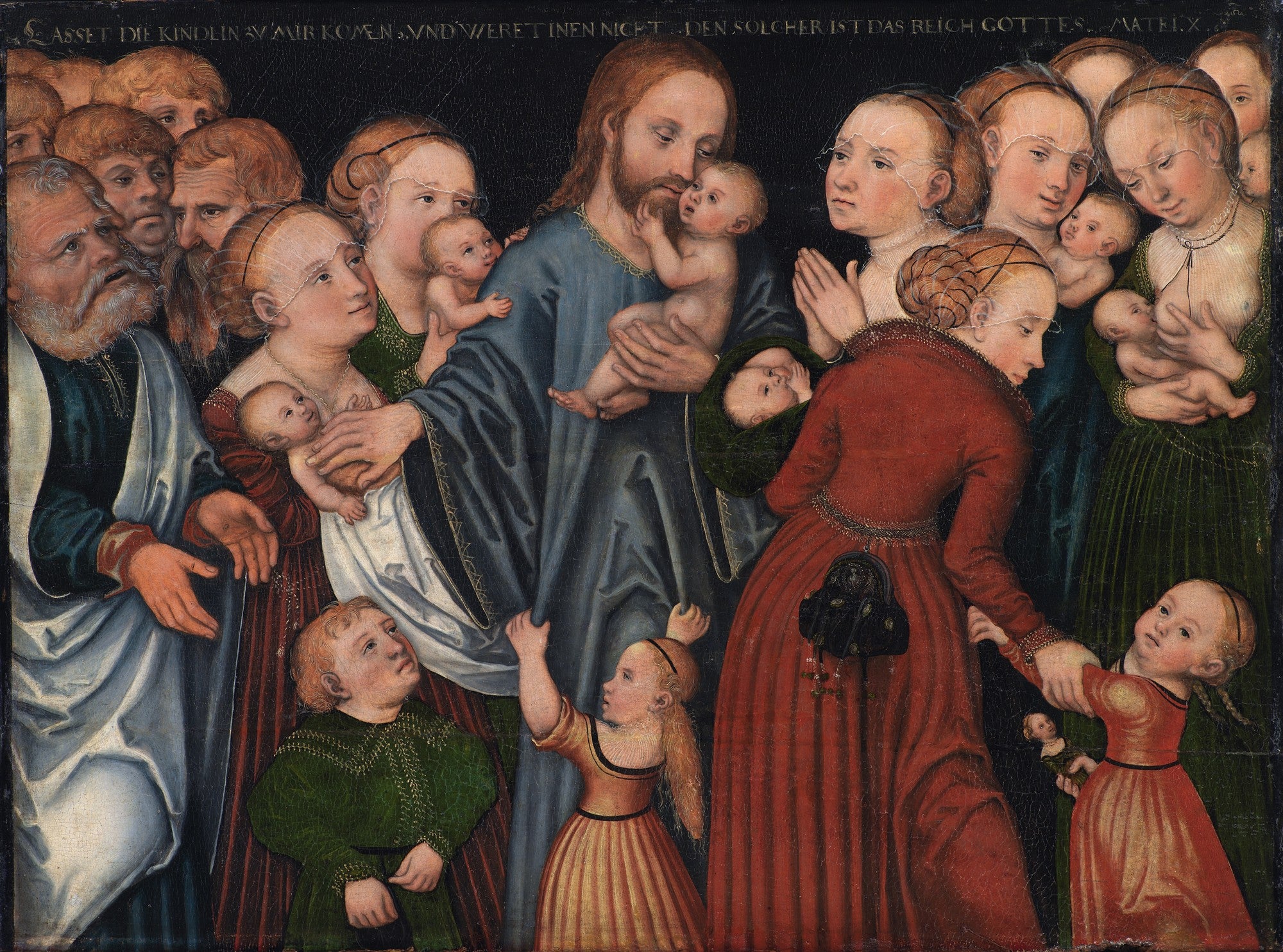 Pintura de Lucas Cranach, o Velho, representando Jesus Cristo no centro, rodeado por um grupo de crianças e adultos. Jesus segura uma criança enquanto outras crianças são apresentadas a ele por mulheres e homens. A cena é emotiva e mostra a interação entre Jesus e os pequenos. O fundo é escuro e há uma inscrição em latim na parte superior.
