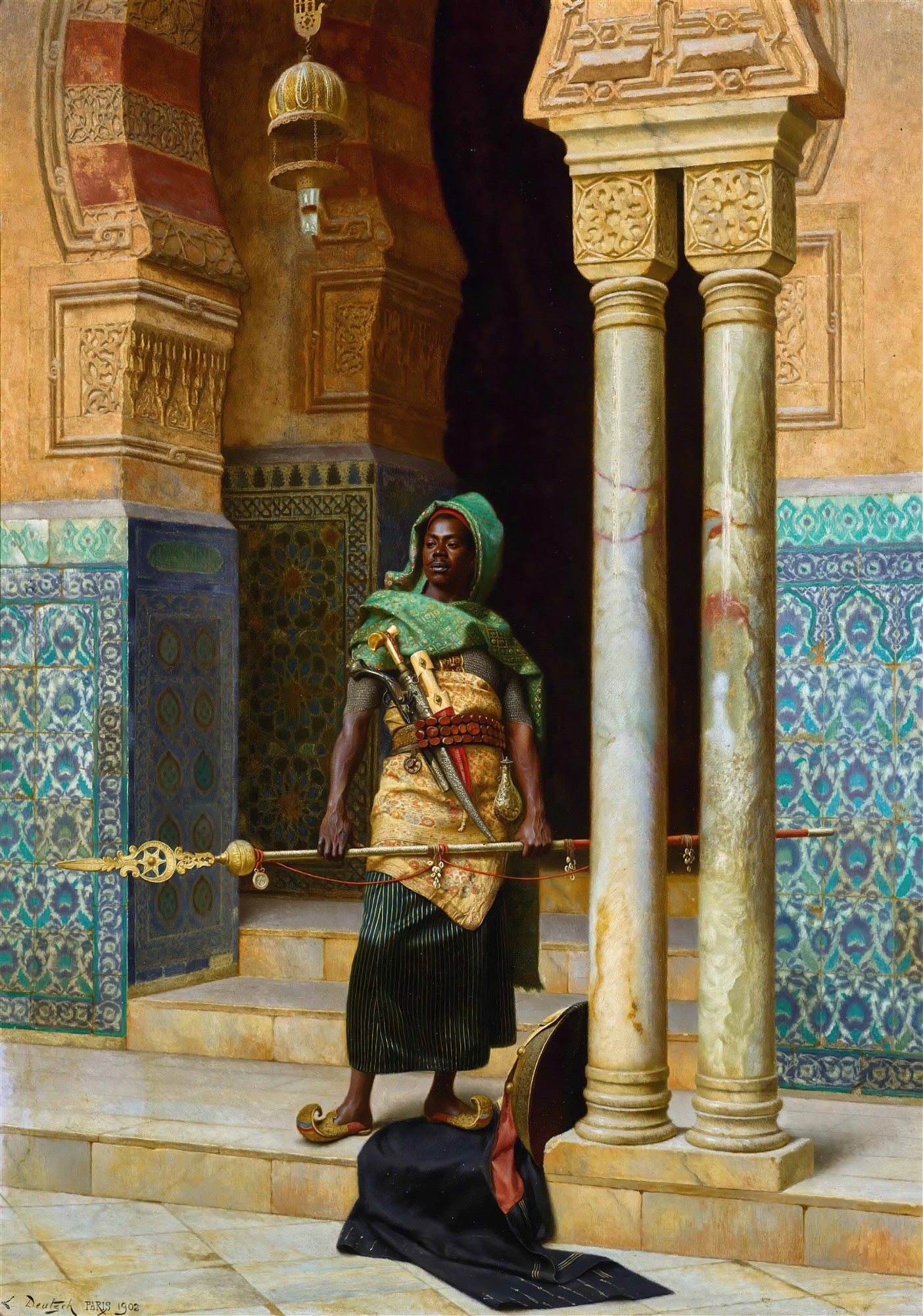 Quadro decorativo de Ludwig Deutsch, 'O Guarda do Harém', retratando um homem de pele escura com turbante verde e roupas ricamente detalhadas, segurando uma lança dourada, em um ambiente arquitetônico islâmico com mosaicos e colunas. Um manto escuro está no chão à frente.