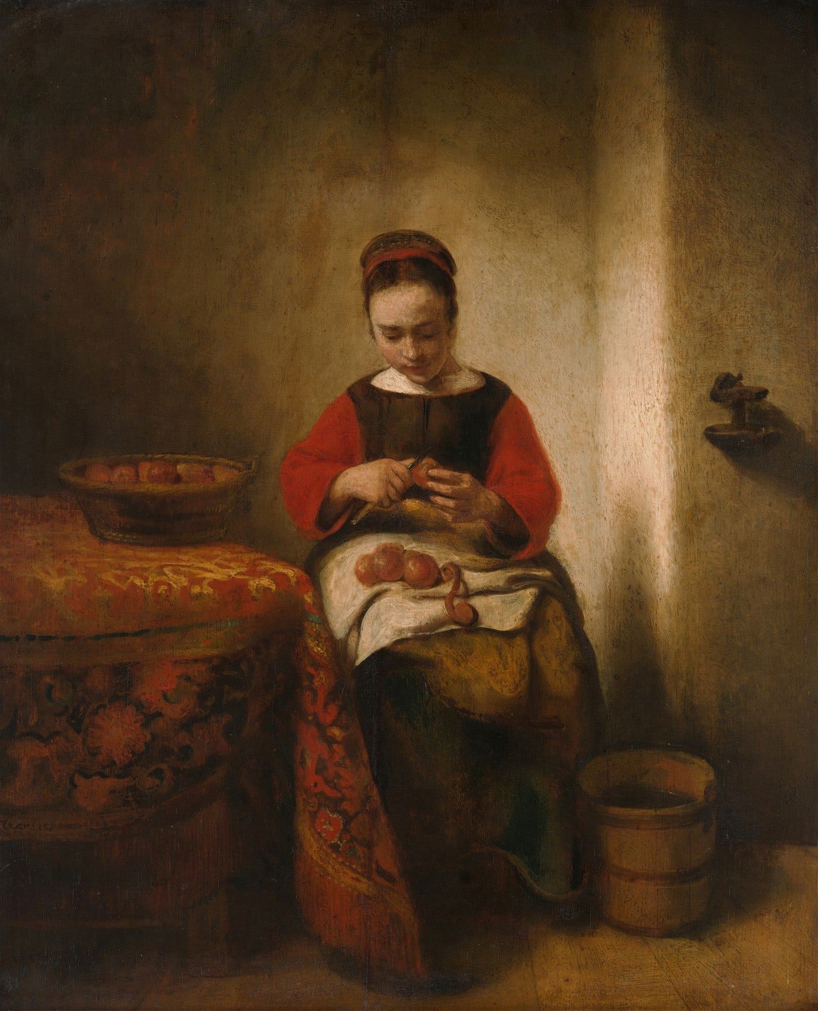 Uma pintura a óleo do século XVII de Nicolaes Maes, intitulada 'A Mulher Descascando Maçãs', retratando uma jovem em um interior escuro, iluminada por uma luz suave, concentrada em descascar maçãs. Ela veste roupas simples em tons de vermelho e marrom, sentada ao lado de uma mesa coberta por um tecido ricamente estampado. No canto inferior direito, há um balde de madeira.
