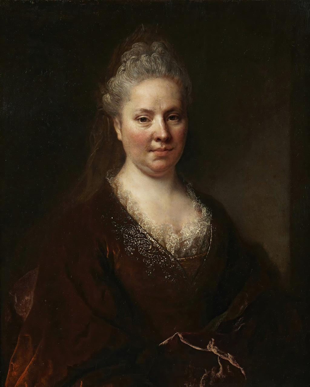 Retrato de uma mulher de meia-idade com cabelo grisalho preso, vestindo um robe de veludo marrom escuro com renda branca no decote, olhando diretamente para o observador, com fundo escuro. Atribuído a Nicolas de Largillière.