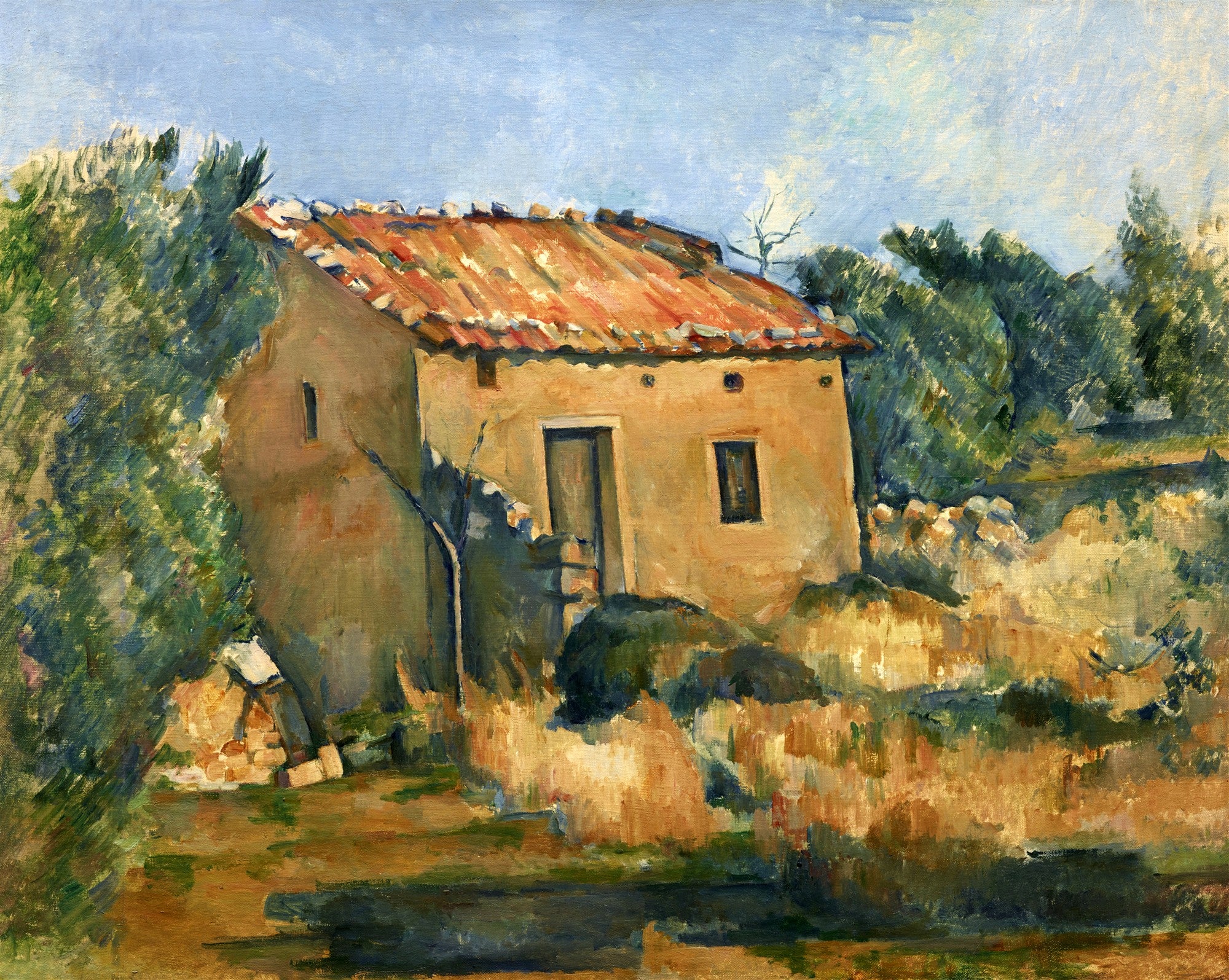 Quadro decorativo da pintura 'A Casa Amarela' de Paul Cézanne, mostrando uma casa rural ocre com telhado de telhas vermelhas, cercada por vegetação densa e um céu azul claro. As pinceladas são visíveis e a composição transmite profundidade e volume.