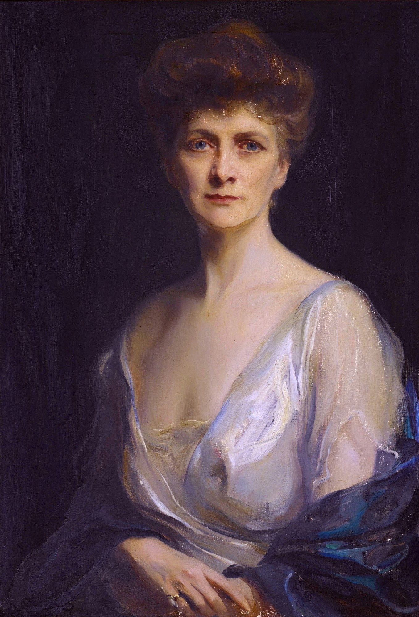 Retrato a óleo de uma mulher elegante de Philip Alexius de László, com cabelo castanho-avermelhado preso e um vestido branco que revela o colo, fundo escuro. A mulher tem olhos azuis e expressão serena. Uma joia brilha em seu dedo anelar. A pintura é escura com foco na figura feminina iluminada.