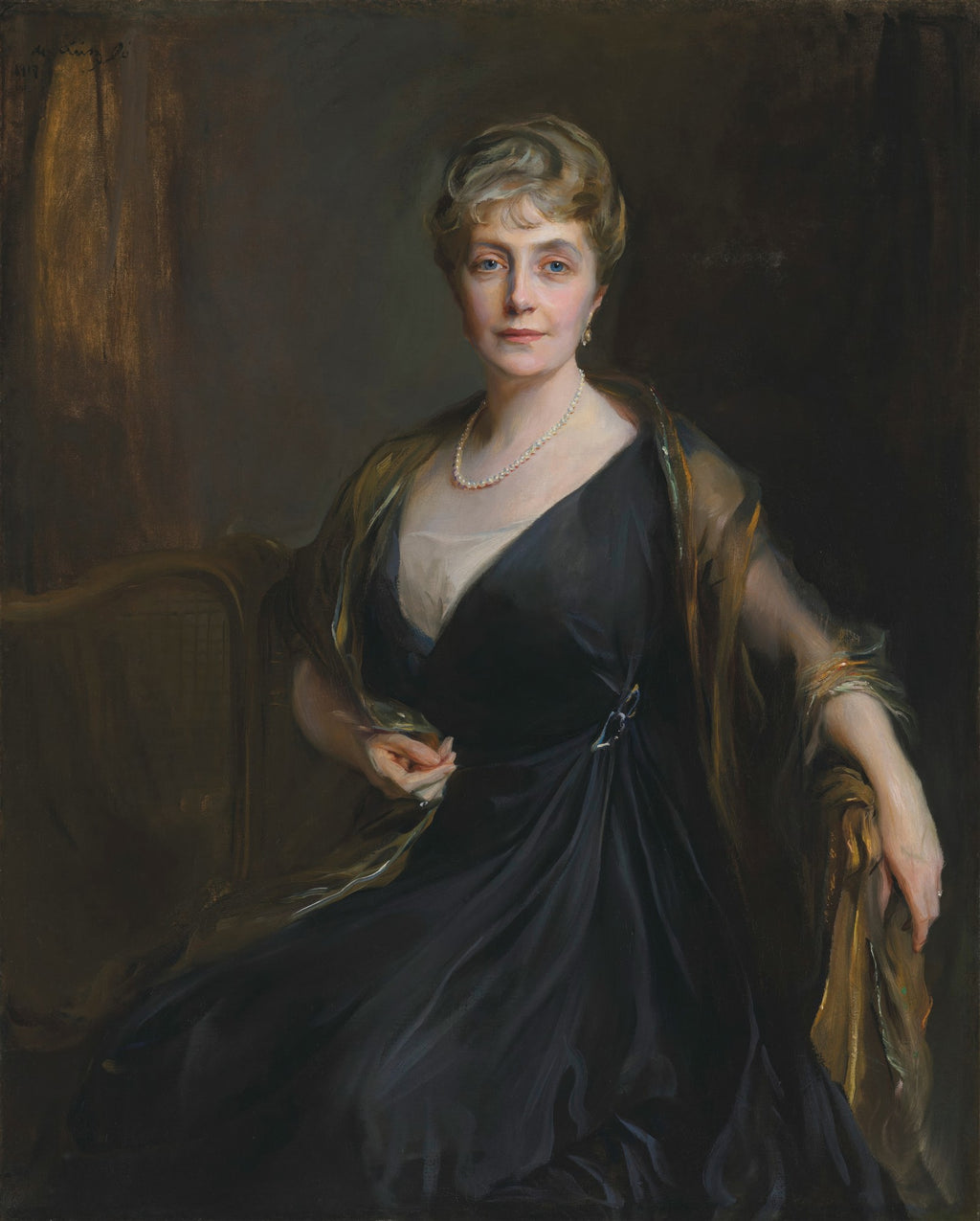 Retrato de uma senhora elegante com colar de pérolas, vestindo um vestido escuro e uma estola dourada, sentada em um ambiente clássico. Obra atribuída a Philip Alexius de László.